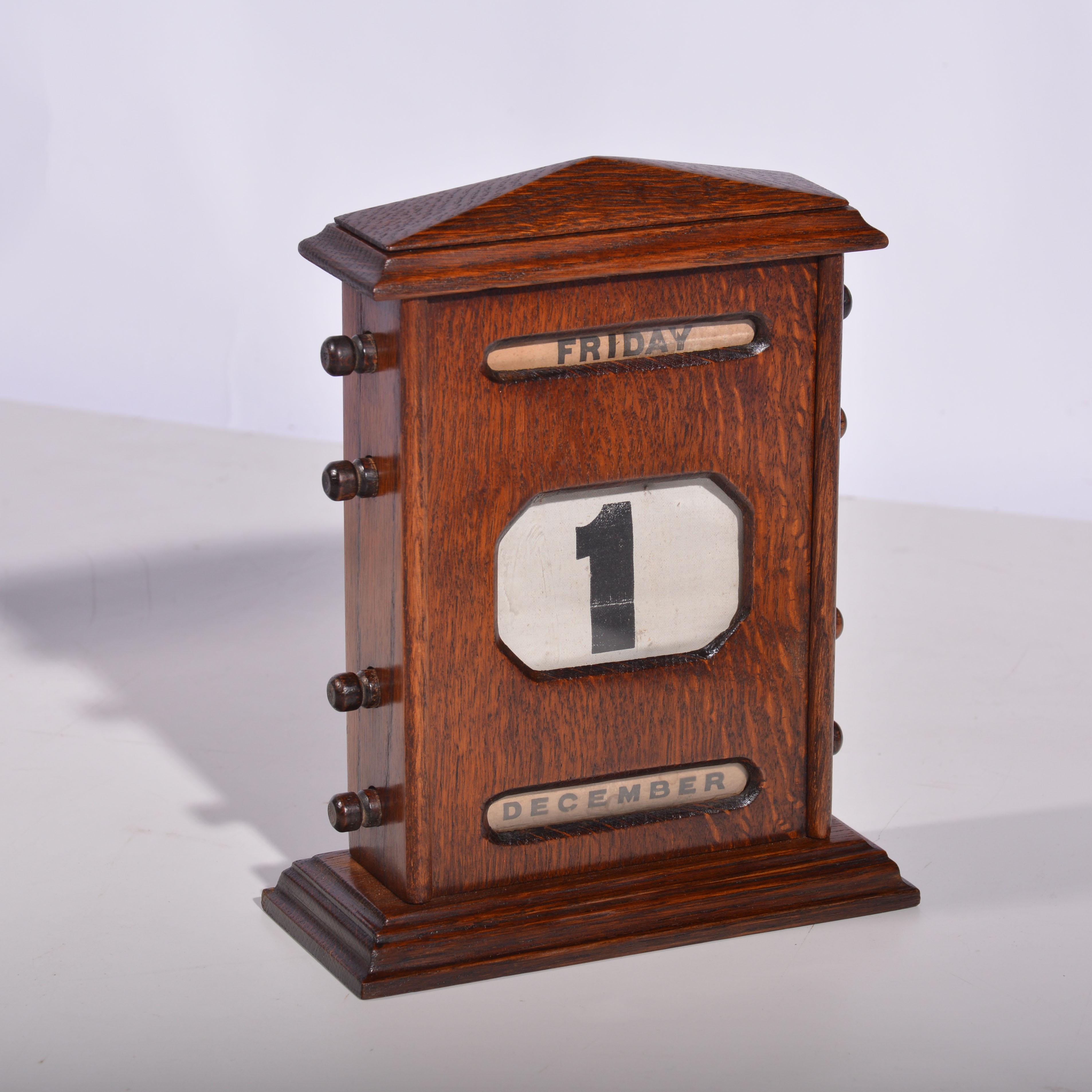 Un grand calendrier perpétuel en chêne de l'époque édouardienne. Pour montrer l'échelle, il est illustré avec un calendrier de bureau de taille standard (seul le grand calendrier est à vendre). Caisse en chêne avec dessus à fronton et base en