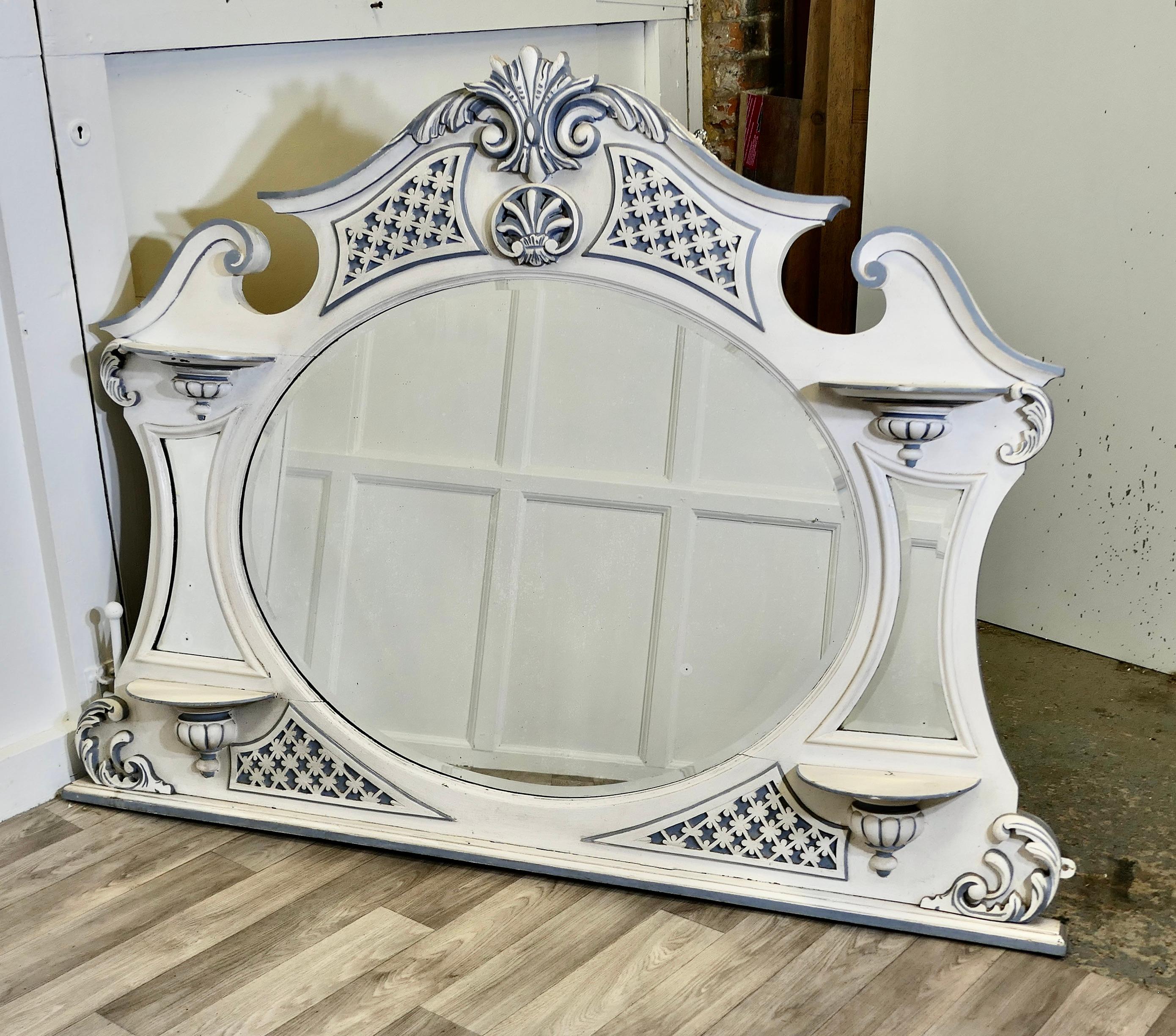 Large Edwardian Painted Overmantel 

This is an attractive piece, it has a bevelled oval mirror at the centre with shaped mirrors on each side and small bracket shelves. The Mantle has a swan neck pediment to the top, and delicate fretted carving