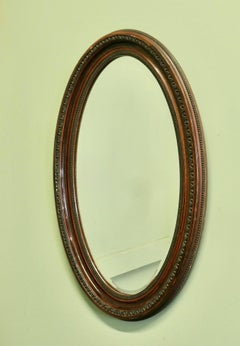 Grande specchio ovale in stile edoardiano con finitura in legno. Questo specchio ha una cornice ovale modanata larga 3”