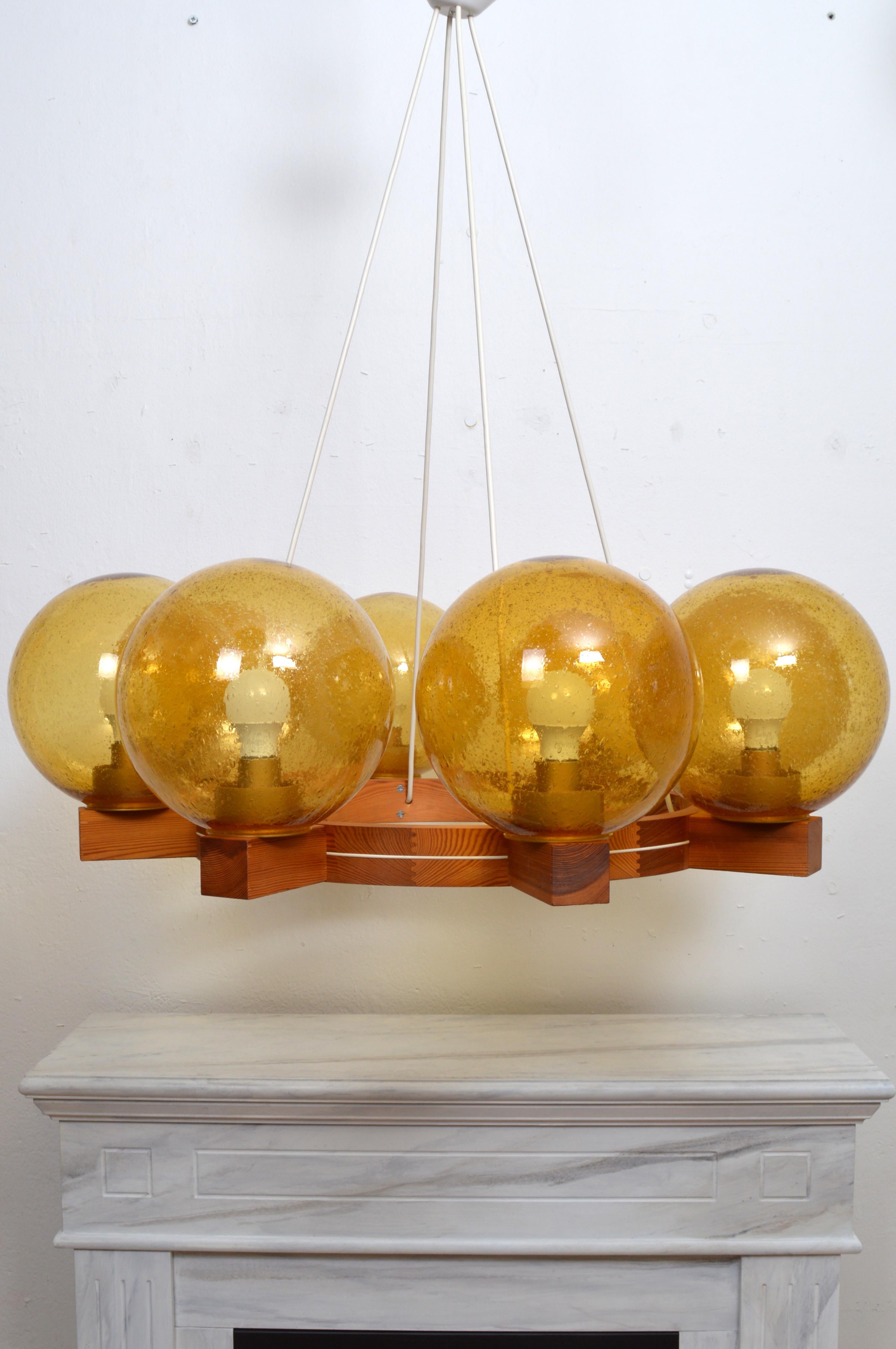 This NOS; New Old Stock, never used solid pine wood, eight arm chandelier was created in this “golden age of Scandinavian design”, a period that saw the revival of an elementary, undecorated visual language, emphasizing sleek design and