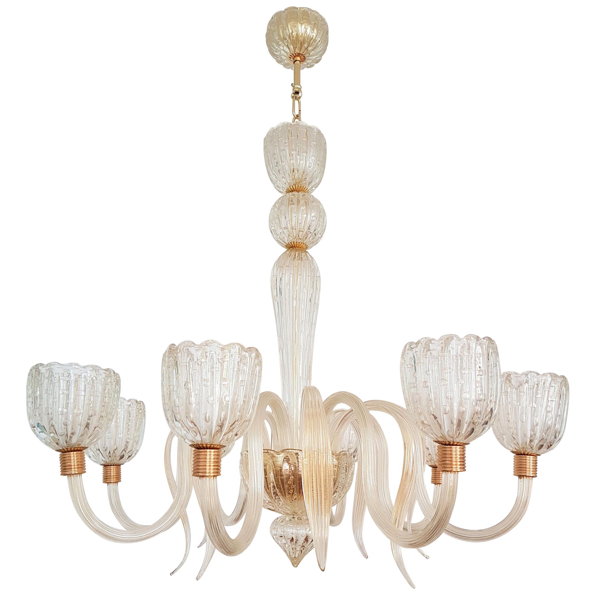 Large clear and gold leaf, handmade Murano glass chandelier, in the style of Barovier e Toso, early 1950s designs.
Glass technique: Balloton: air bubbles inclusion, circled by gold.
Brass mounts.
The chandelier has a double canopy.
The height of