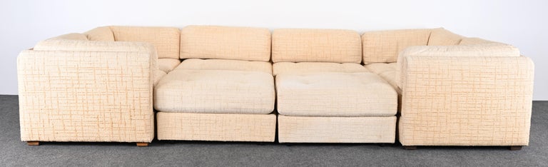 A Milo Baughman style eight-piece sectional sofa including ottomans by Selig. This set would look great in a contemporary or mid-century modern setting. Upholstery is vintage and needs reupholstery however, you are buying a sturdy frame. Would look