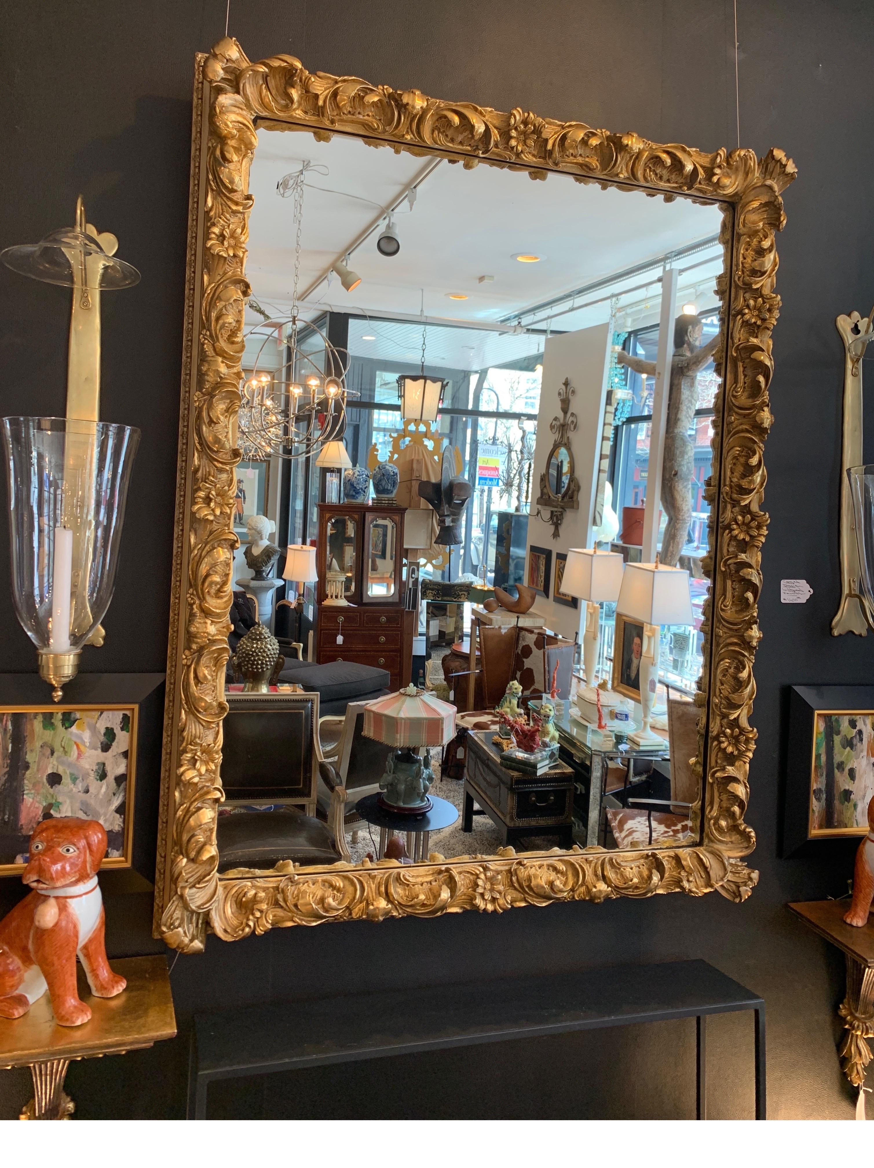 A large rectangular mirror with highly detailed frame. The frame of giltwood and gesso plaster with original gilt finish, with some minor touch up and wear to frame, circa 1910-1920.