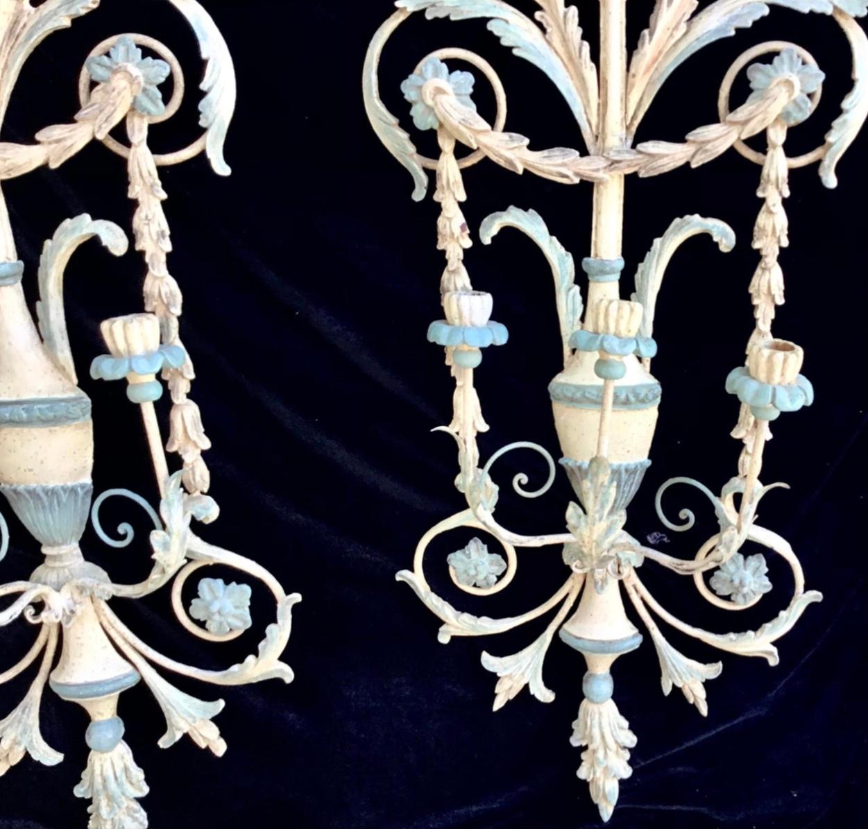 Pair of Venetian wall sconces, Italy. Elaborate painted details. Solid wood, mounted on metal frames. Carved and painted in a wonderful mix of color. 3 arms each. Richly ornamented and ornate body and design with floral scrolls and urns topped with