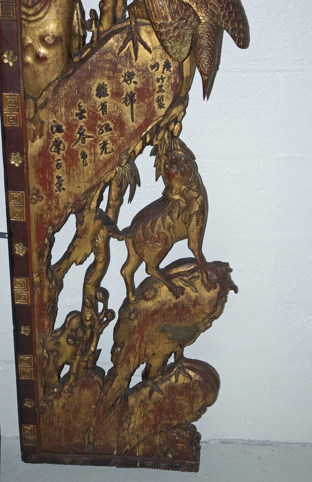 An impressively beautiful and rare Chinese architectural surround of intricately & finely-carved wood with gilding, depicting foo dogs & birds that include ibis & starlings perched on branches with peonies & plum flowers. Qing Dynasty, circa early