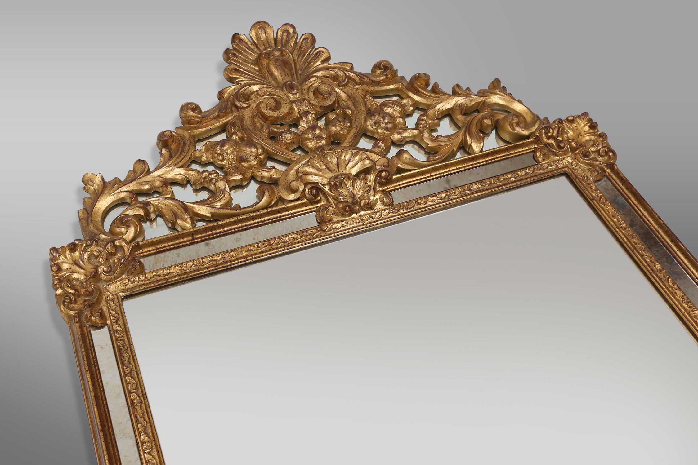 Belgian Large elegant gilted mirror with stunning ornamentation on the top, Deknudt  For Sale