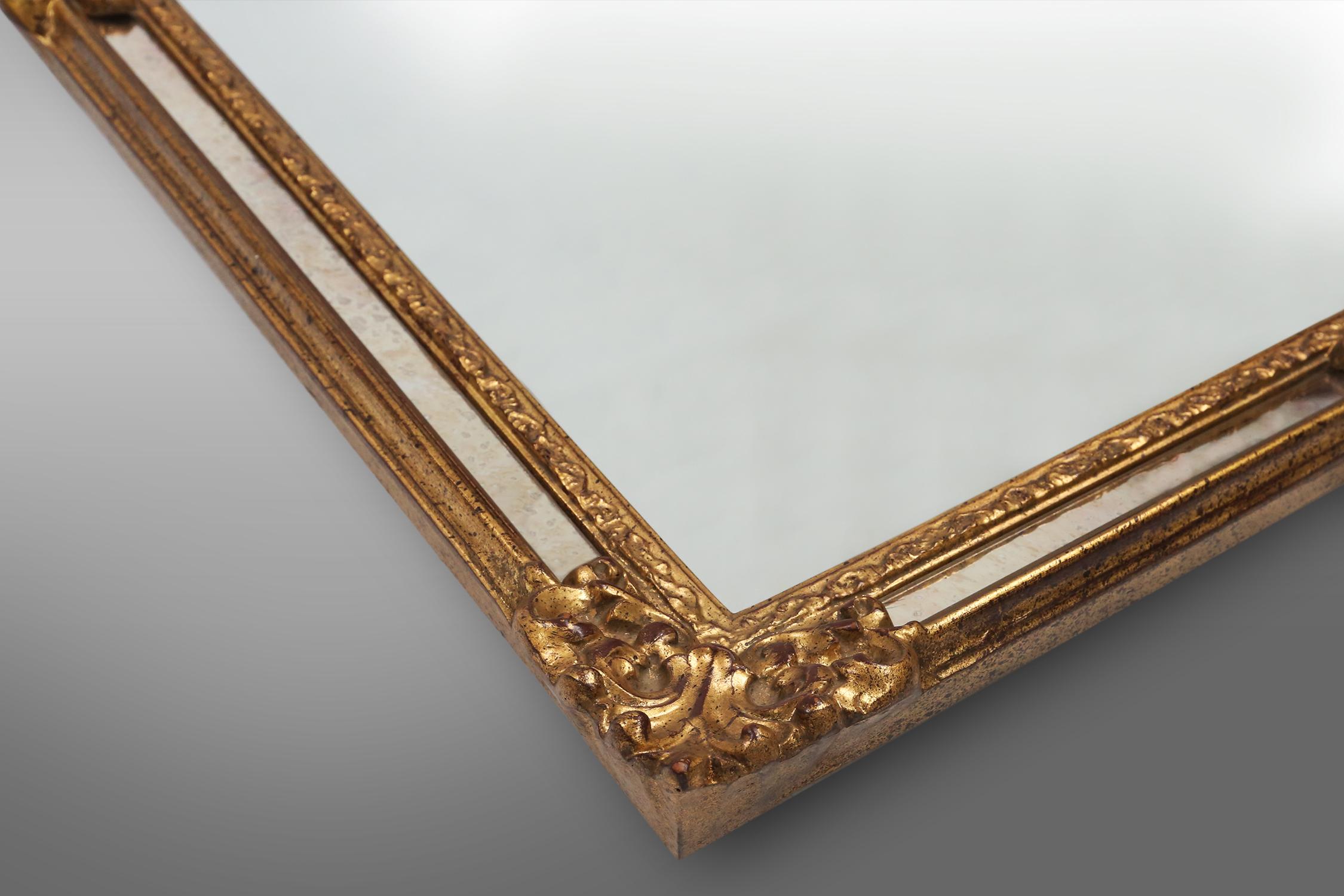Late 20th Century Large elegant gilted mirror with stunning ornamentation on the top, Deknudt  For Sale