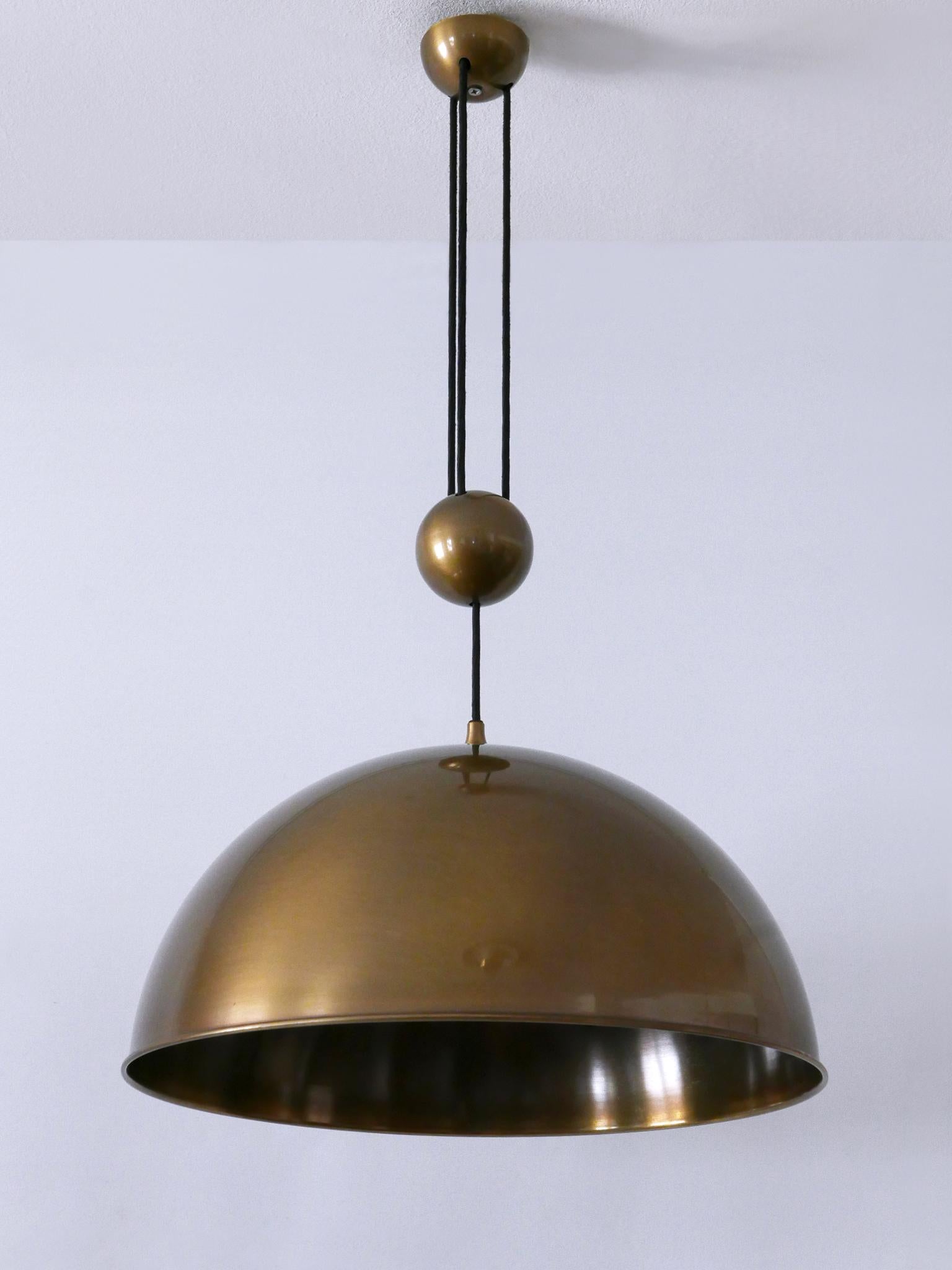 Rara, grande ed elegante lampada a sospensione a contrappeso in ottone del Mid-Century Modern con finitura in bronzo. Progettato e realizzato da Florian Schulz, anni '1970, Germania.

Realizzata in ottone massiccio, la lampada è dotata di 1 attacco
