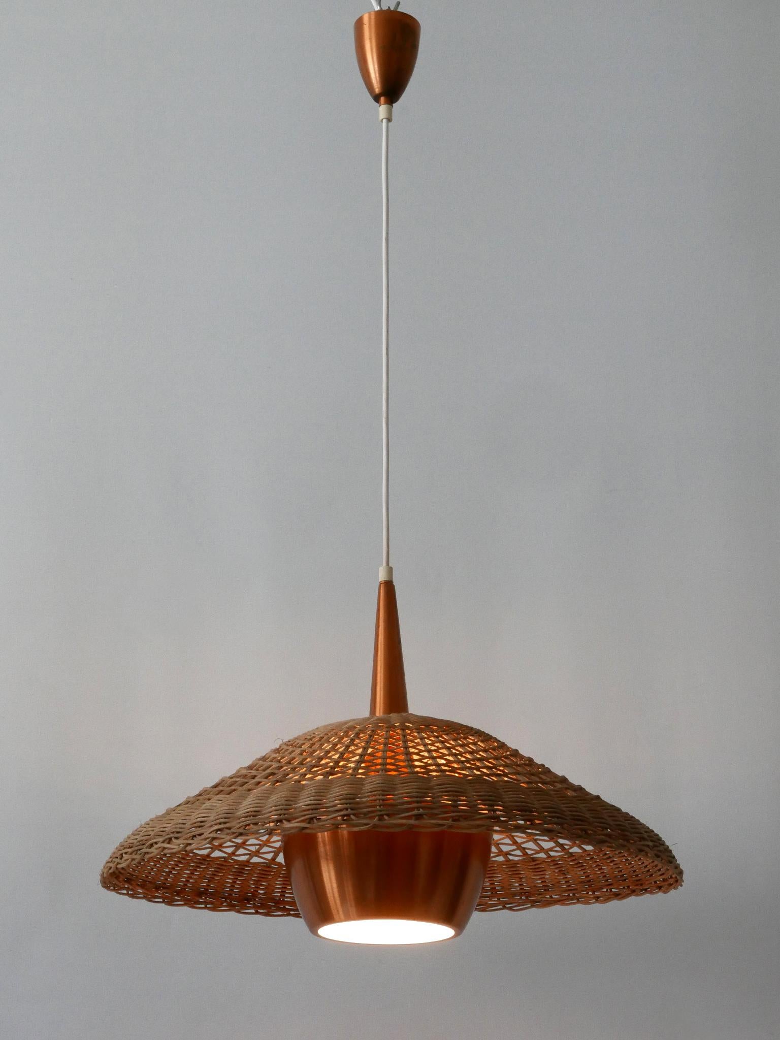 Large and highly decorative Mid-Century Modern pendant lamp or hanging light. Manufactured probably in 1970s, Denmark.

Executed in rattan and copper, the pendant lamp comes with 1 x E27 / E26 Edison screw fit bulb holder, is rewired and in working