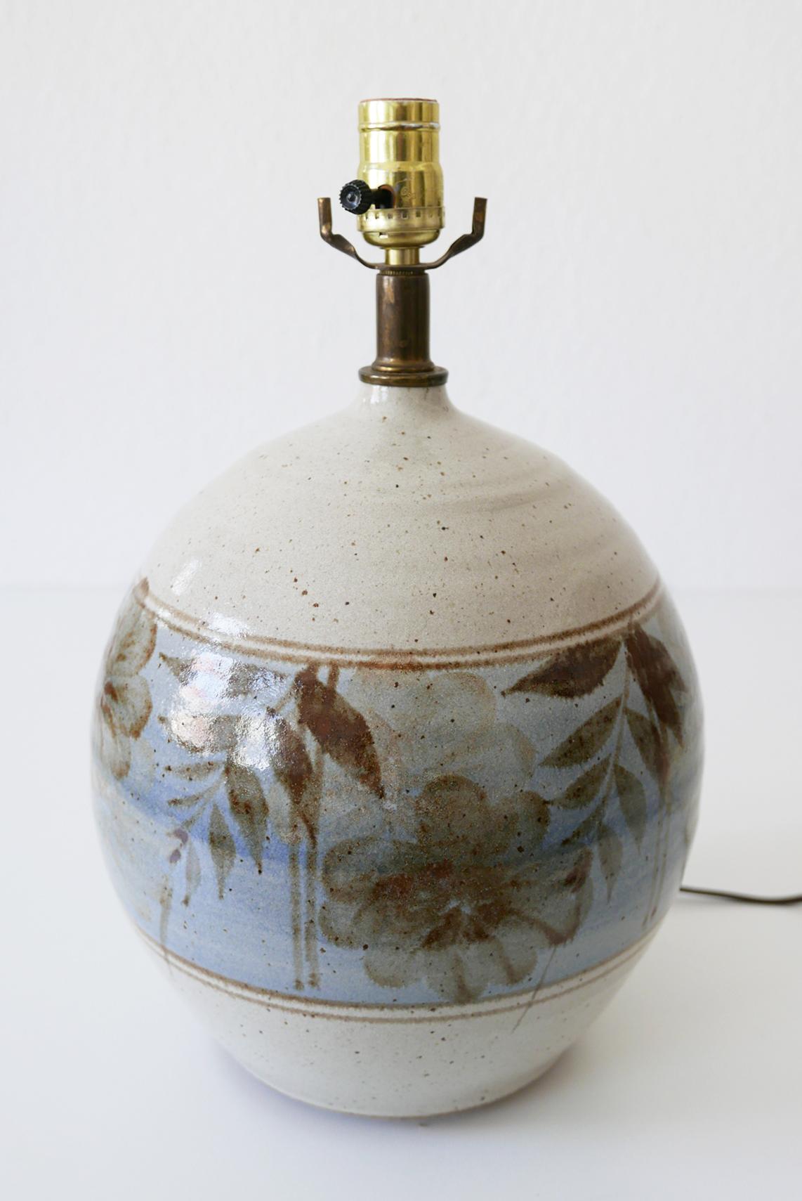 Elegant and big-sized Mid-Century Modern stoneware side table lamp. Made by California Ceramic Company in 1970s, USA.

Executed in beige, brown and blue colored stoneware with floral motifs. The lamp comes with 1 x E27 Edison screw fit bulb