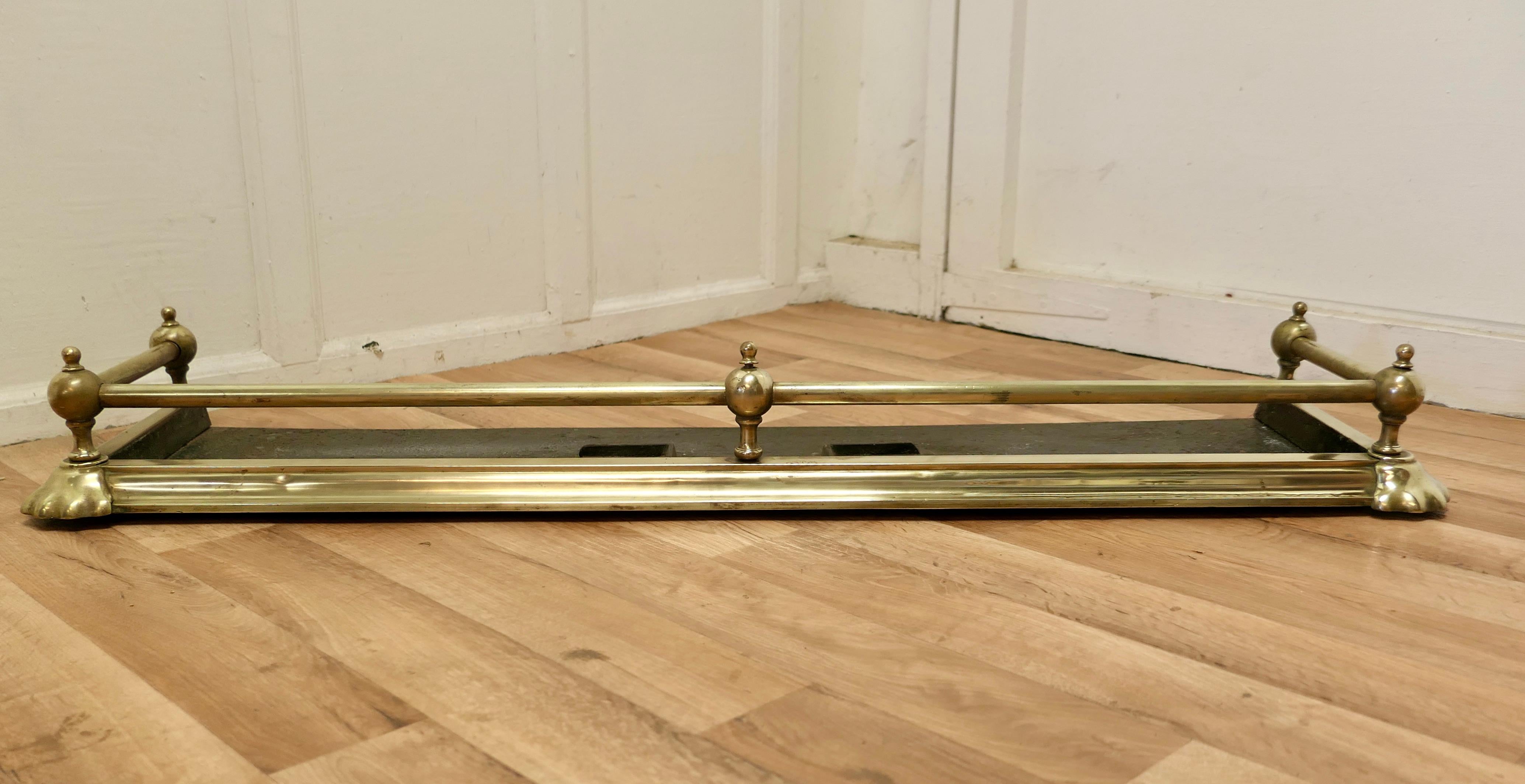 Large elegant Victorian brass fender 

This is a very attractive brass fender it has a deep brass base with a brass rail above and chunky Brass Knobs supporting the rail with decoration to the corners of the base

The Fender is in Very good