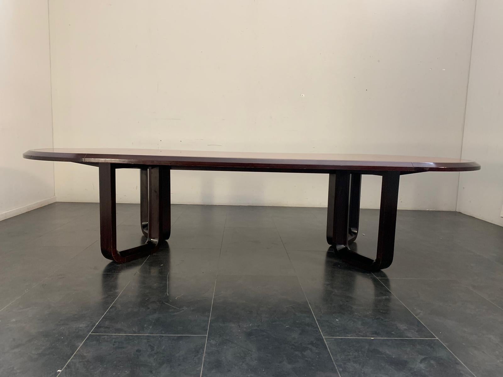 Large elliptical table, probably made on commission; 4 curved and shaped supports in solid mahogany support the oval top with a triumph of selected solid rosewood in the center framed by a sloping band composed of 7 mahogany profiles of about 1 cm