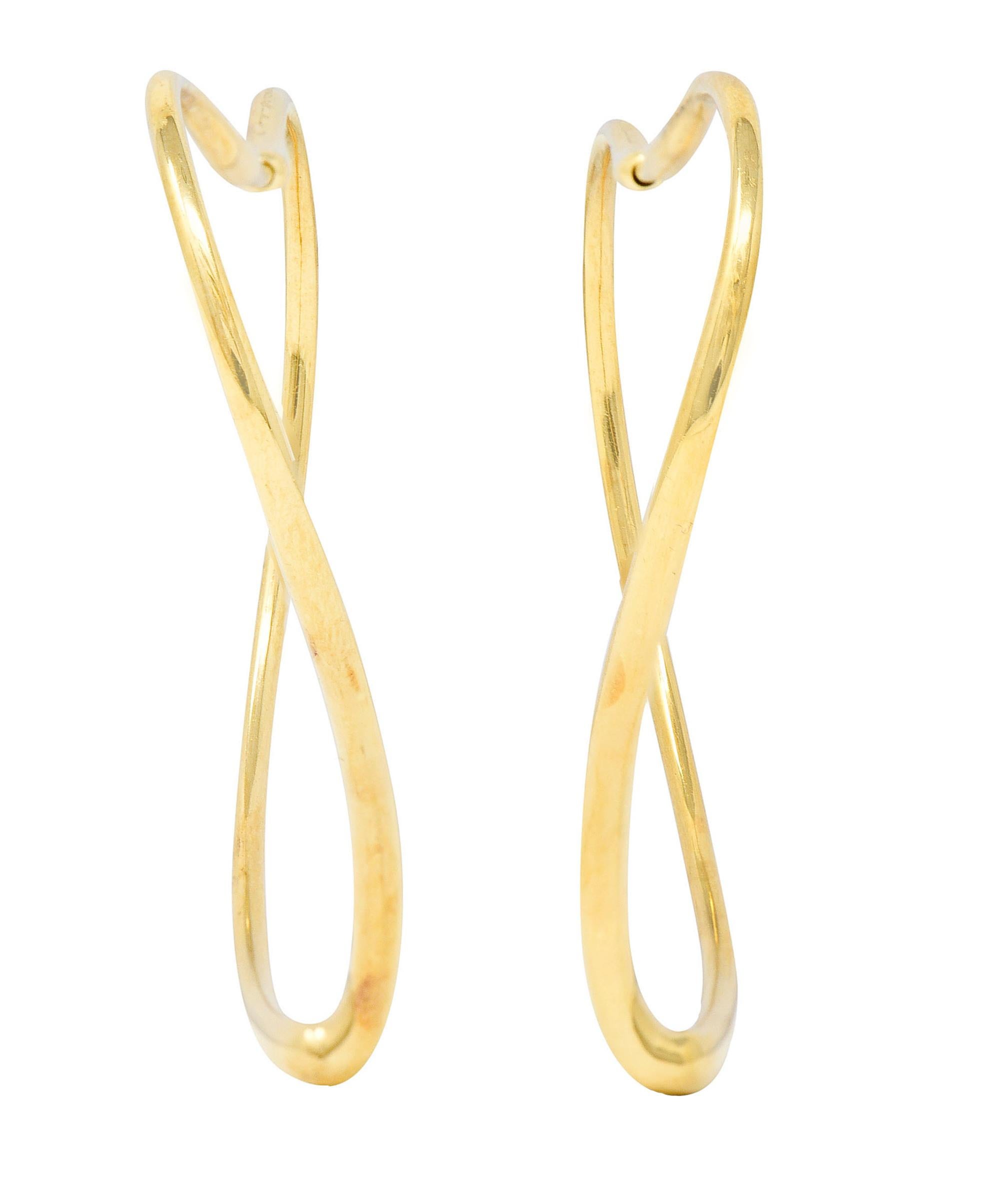 Hoop style earrings are organically shaped as a stylized open heart motif

With broad shoulders fancifully torqued to echo a heart shape

Completed by concealed posts

Stamped 750 for 18 karat gold

Fully signed Tiffany & Co. Elsa Peretti

From the