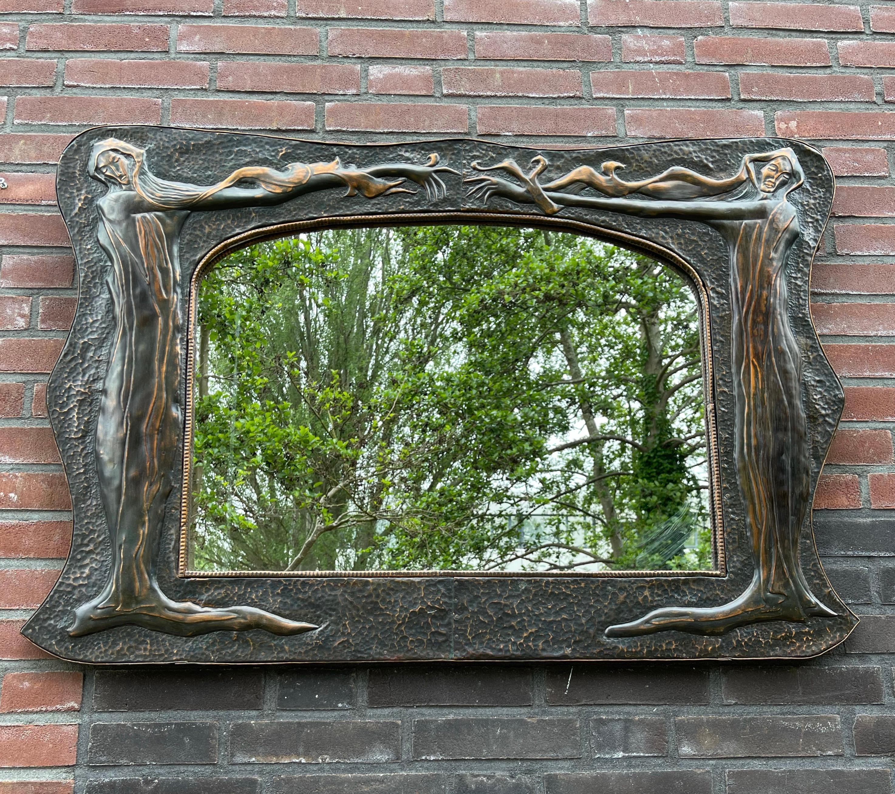 Exceptional design and meaningful wall mirror.

This sizeable and unique wall mirror comes with perfectly embossed, stylized nymph sculptures on either side. For those who did not yet know: a nymph is a mythological spirit of nature imagined as a