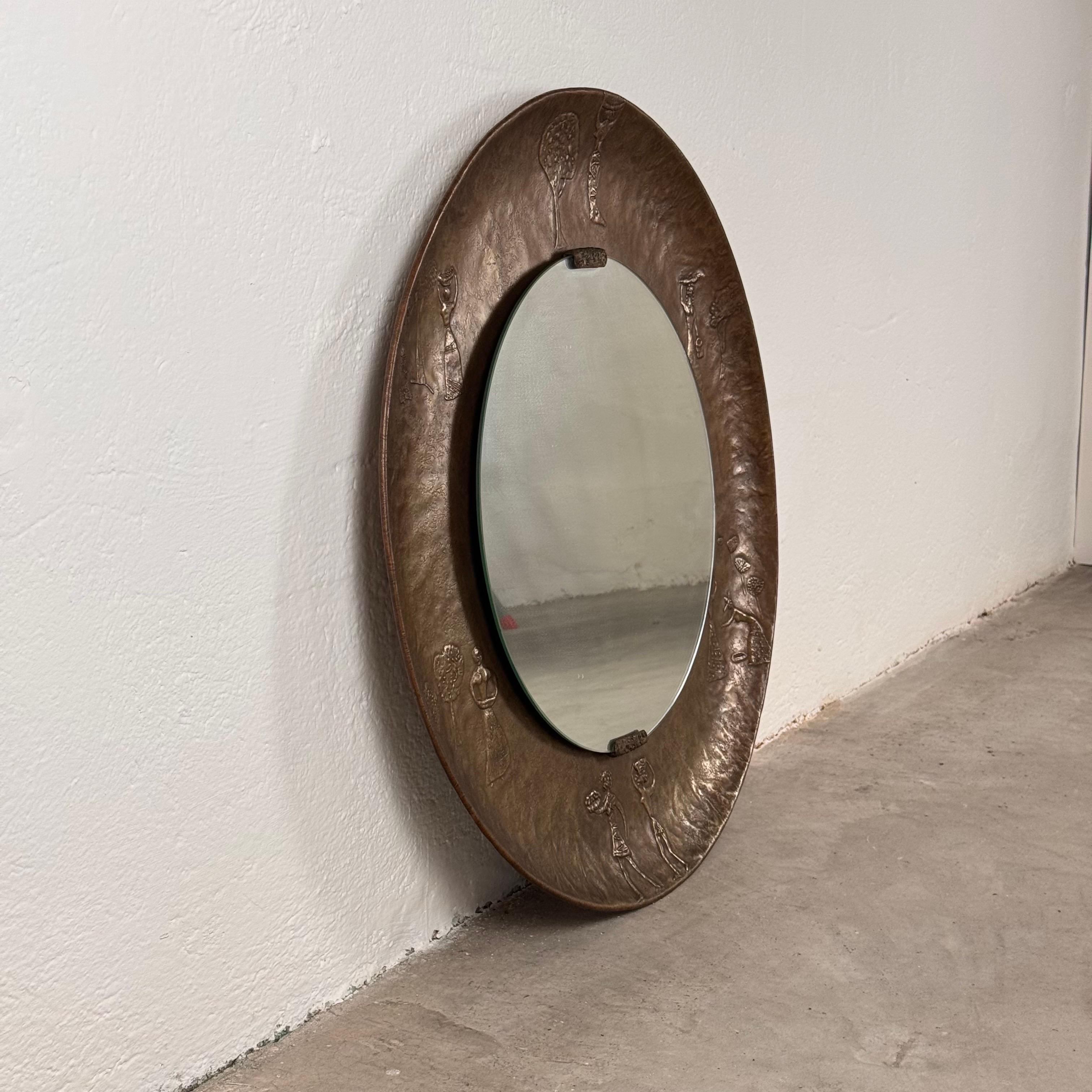 A rare and stunning Italian mirror by Angelo Bragalini from the 1950s, featuring a beautifully hand-crafted embossed and engraved copper frame. This exceptional piece showcases intricate bas-relief decorations depicting scenes of daily life from a