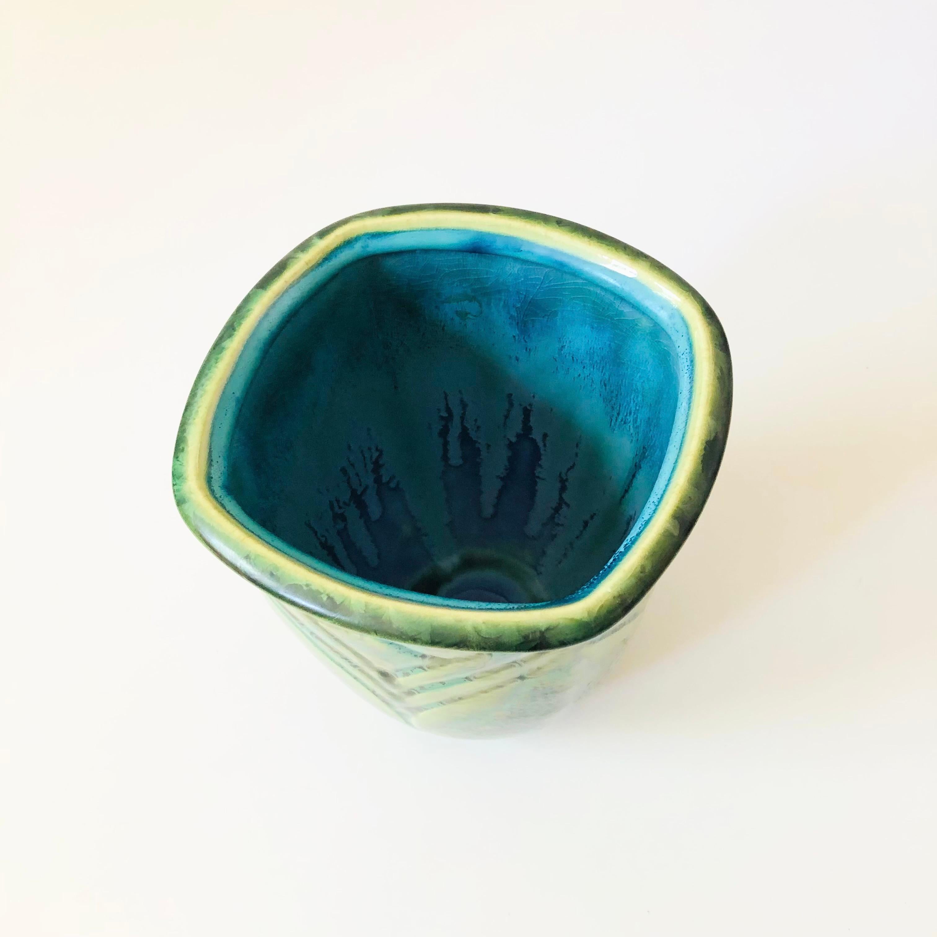 A vintage crystalline pottery vase. Green and blue colored glazes with  an organic pattern of the circular crystals created during the firing process. Unique embossed detailing to the surface. Signed on the base.

