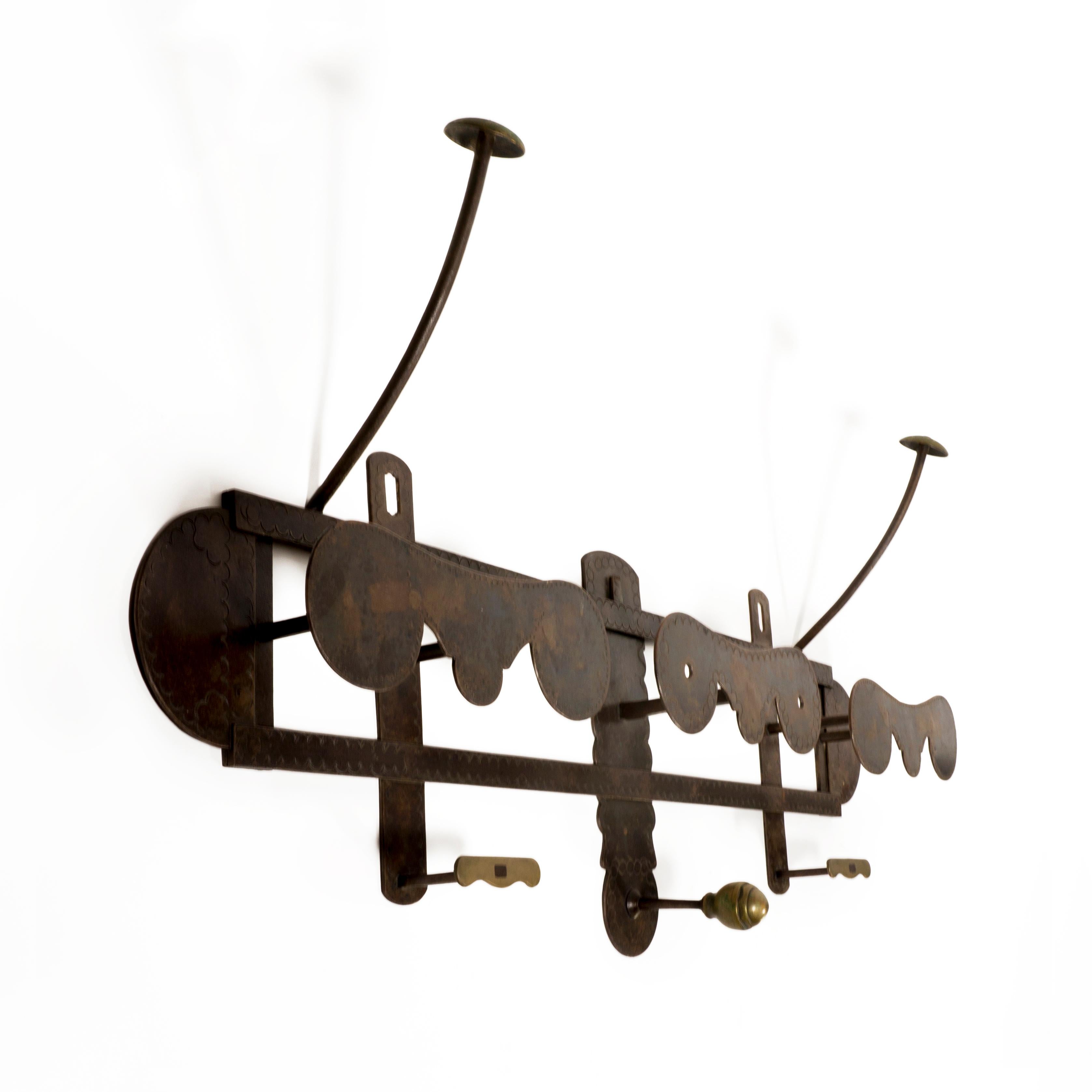 Large and very sturdy italian wrought iron wall mounted coat rack with brass accents.
The embossed wrought iron coat racj is finished with decorative brass details. There are two charming mushroom-shaped hooks for hats, three hooks for hanging