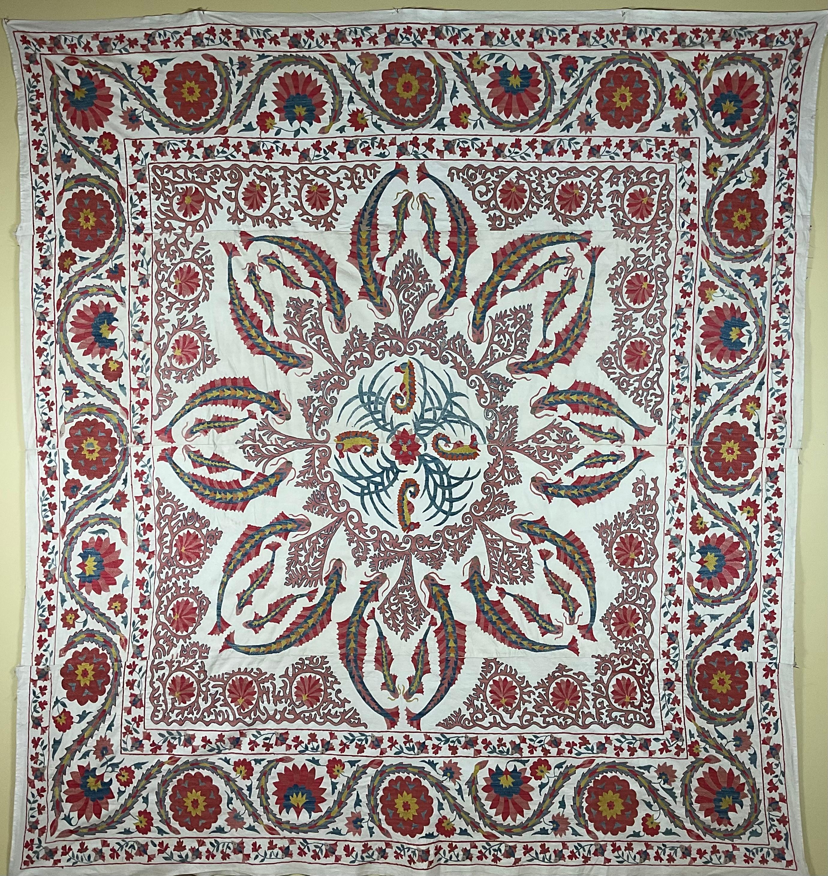 Beautiful artisan Suzani textile made of hand embroidery silk with exceptional sea creature motifs of fish ,seahorse ,coral ,Surrounded by floral and vines embroidery. red, green and indigo colors on cream color background. Could be use as wall