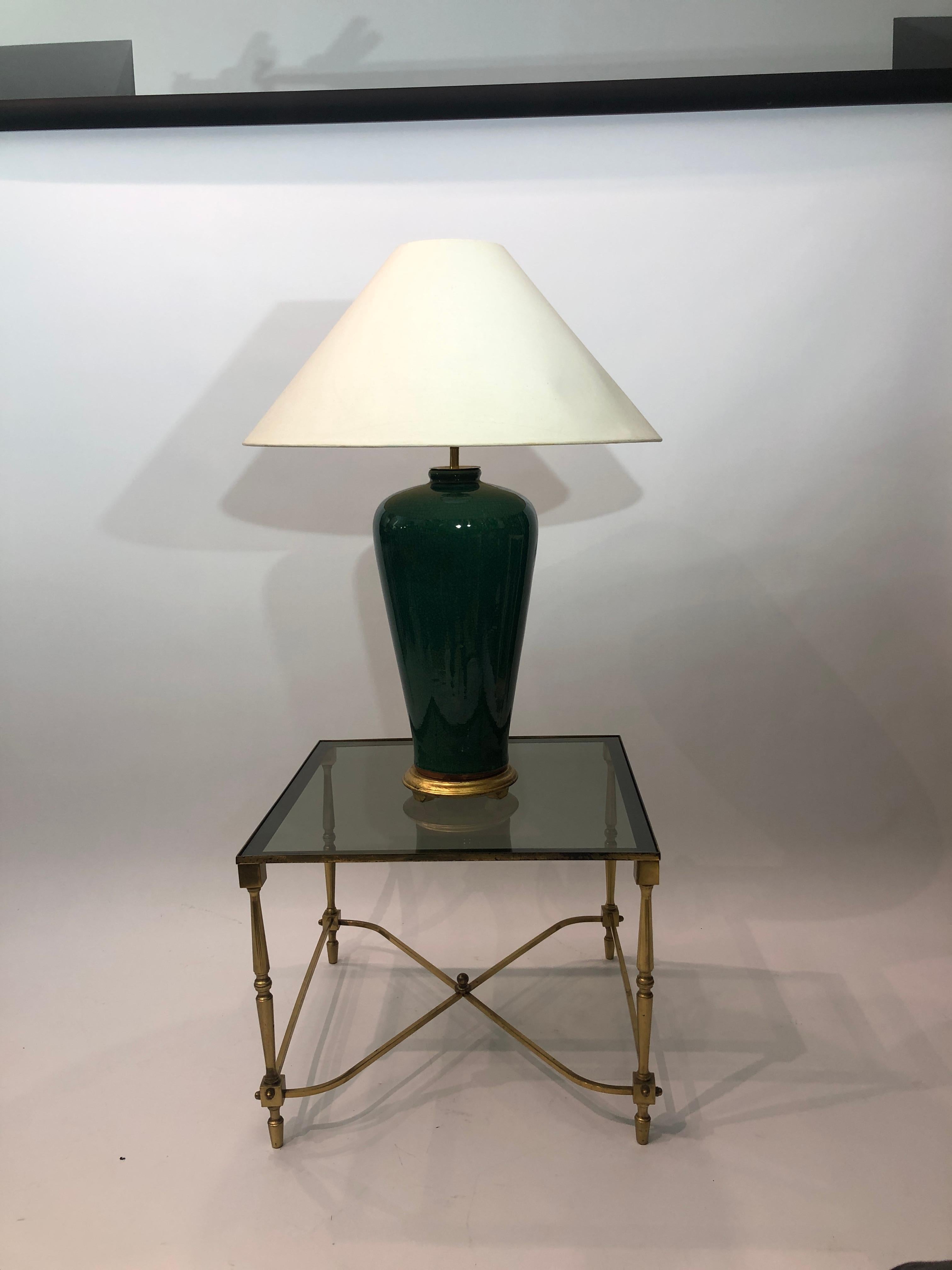 An elegant tall emerald green in cracked glaze ceramic with brass fittings siting atop on a round gold guilted base. 

The lamp would look amazing in most interiors and complement any room.

Shade for display purpose only. This listing is only for