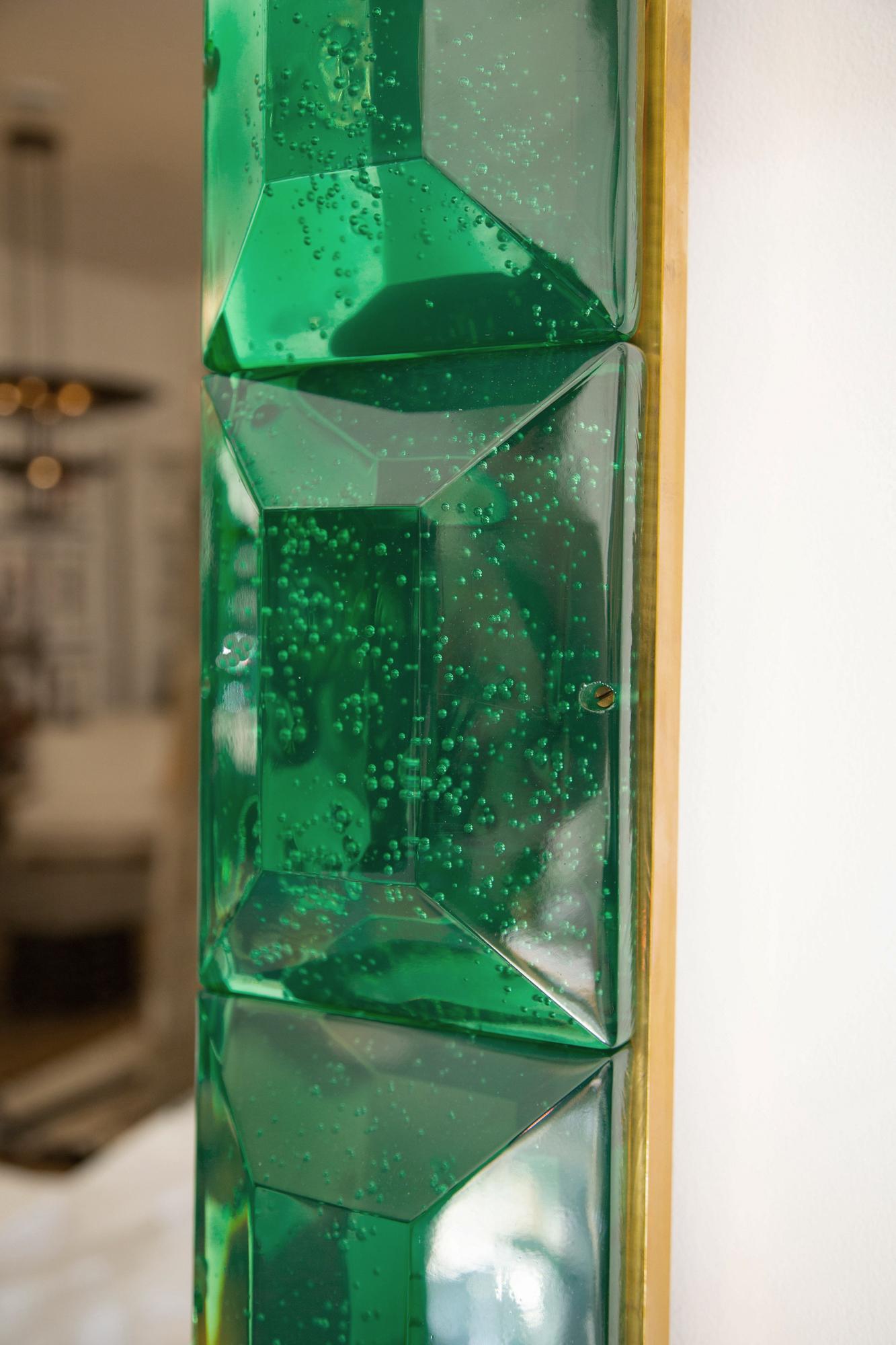 Large emerald green diamond cut Murano glass mirror.
 Vivid and intense emerald green glass block with naturally occurring air inclusions throughout 
 Highly polished faceted pattern
 Brass gallery
 Luxury handcrafted by a team of artisans in