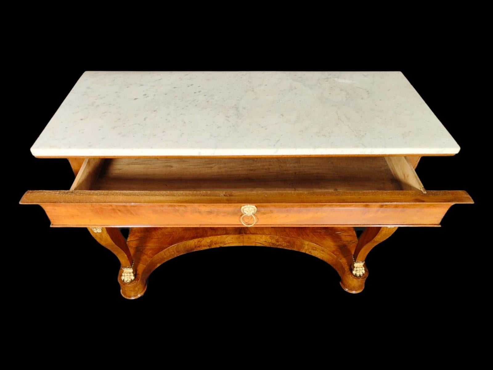 Large empire console from the beginning of 1800-it is made of light fruit wood. It has a white Carrara marble on top. It has lion claws and golden bronze finishes. Excellent condition.
Measures: 125X52X98 cm.