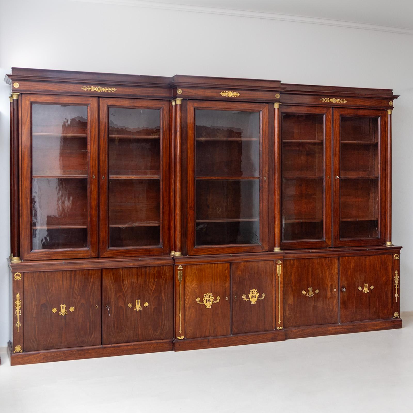 Grande biblioteca con cinque porte vetrate affiancate da colonne nella parte superiore e tre porte doppie nella parte inferiore. I frontali delle porte, le lesene, i capitelli e le basi e il cornicione sono decorati con applicazioni in bronzo dorato