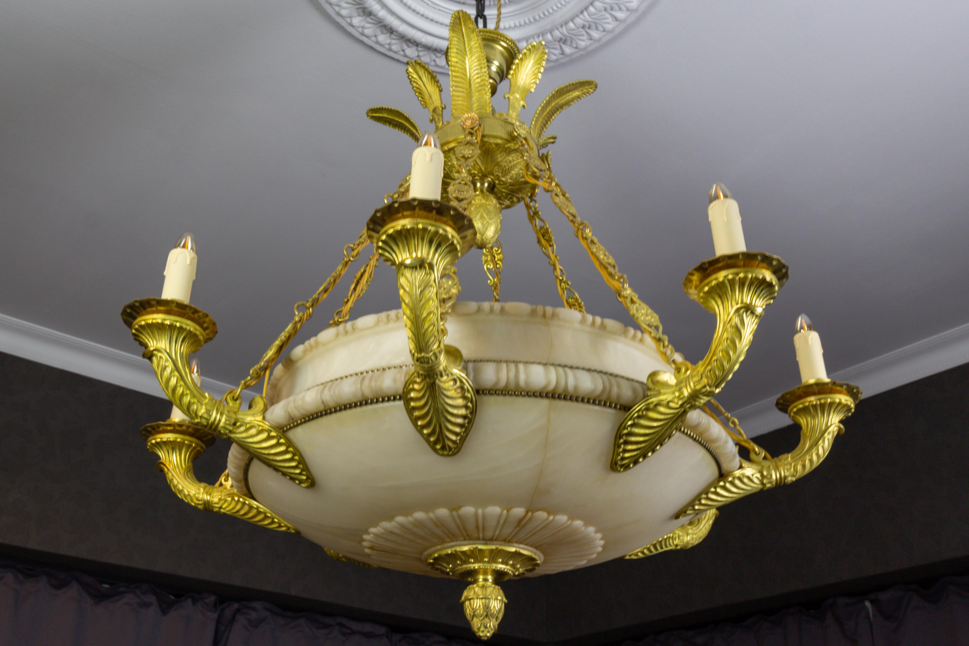 Large Empire-style alabaster and bronze chandelier, Germany, ca. 1920.
An impressive sixteen-light alabaster and bronze chandelier. The extra large, exceptional, and masterfully carved white alabaster bowl features delicate carvings and a bronze