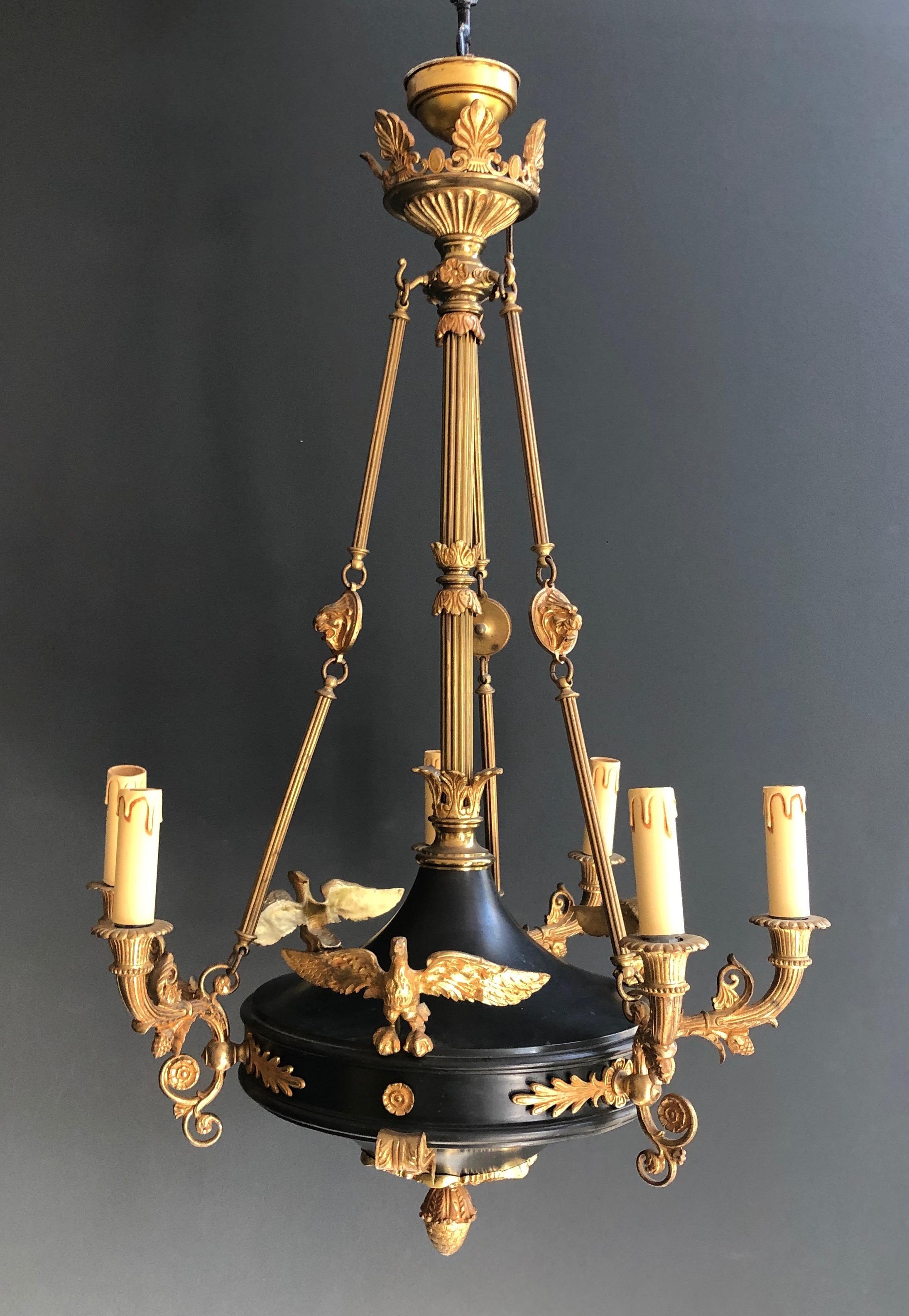 This beautiful large Empire style chandelier is made of green sheet metal and gilded bronzes decorated with ornaments, palm leaves and golden eagles. This is a French work. circa 1920.