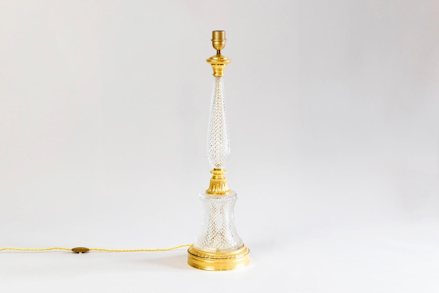 Large Empire style lamp in cut crystal and chiselled and gilt bronze mount. Circular gilt bronze base adorned with a Walter leaves frieze, gadroons and beads topped by a cut crystal piedouche part. Bottom part linked to the crystal baluster shape