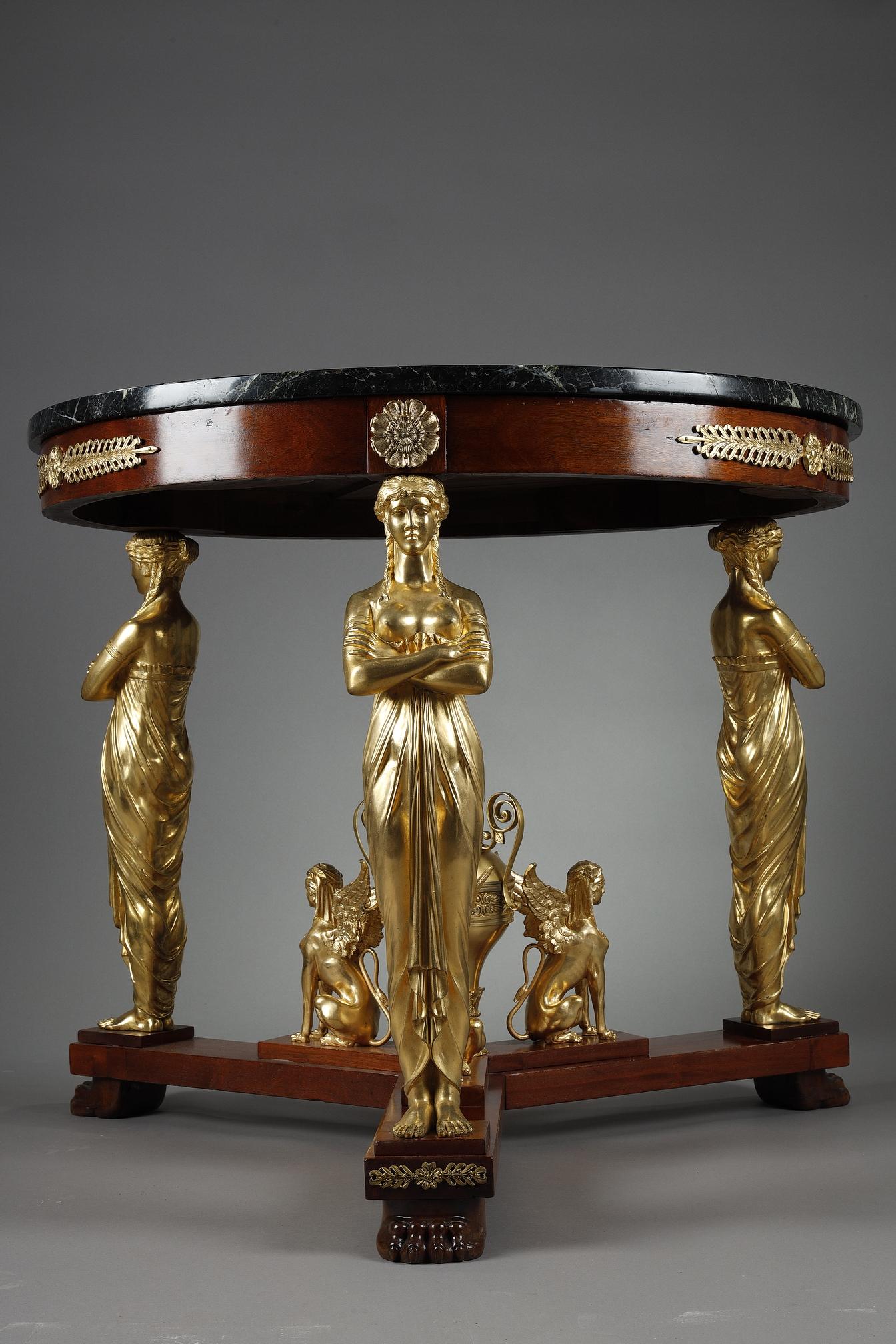 Bellissimo tavolo con piedistallo in stile Impero in mogano e superba montatura in ormolu su modello di Jacob-Desmalter, il piano circolare in marmo verde antico sormontato da un fregio in mogano montato con una fascia di foglie di alloro tra