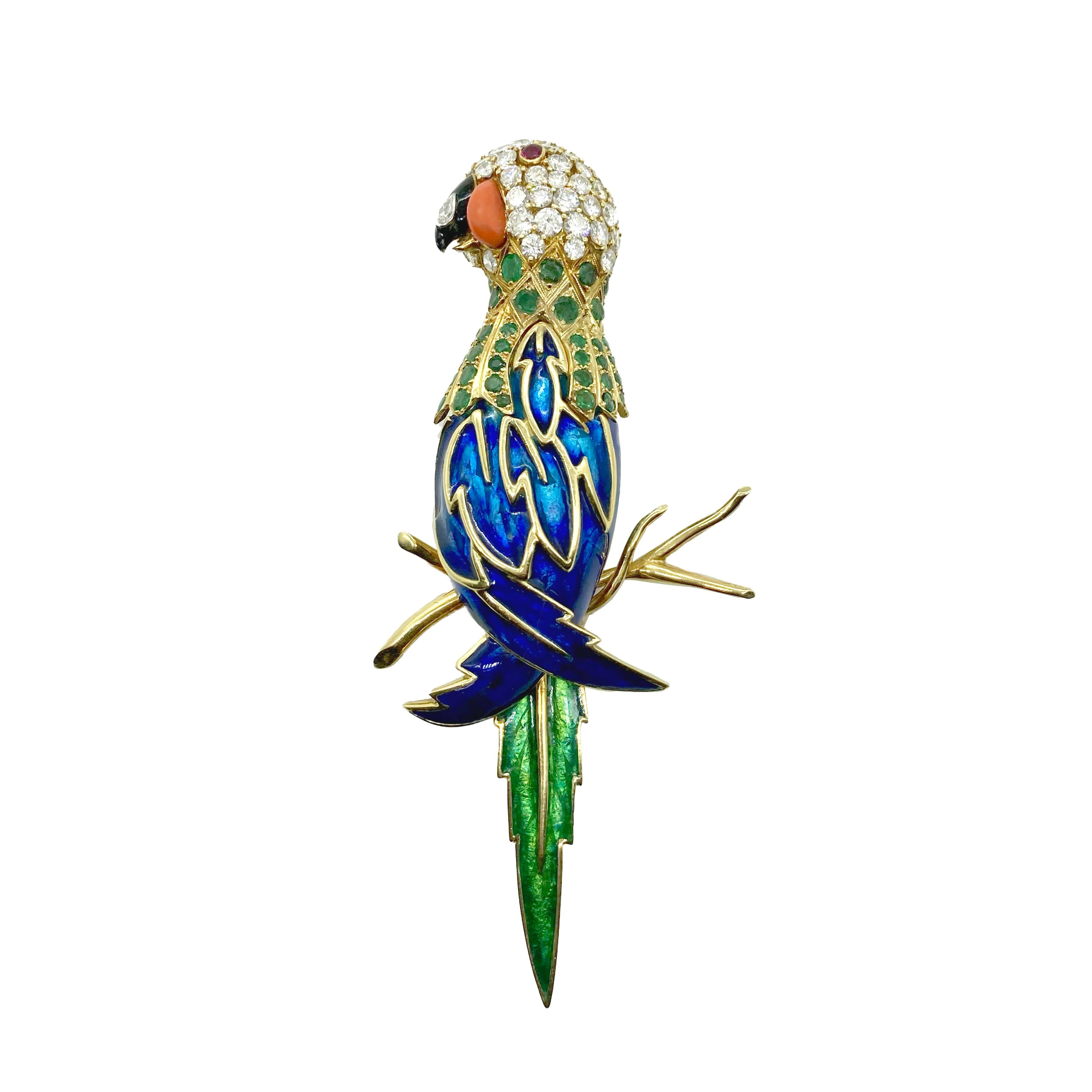 A stunning enamel statement brooch featuring a parrot embellished with 8 carats of round brilliant diamonds, 3 carats of emeralds, coral, and ruby. Mounted on 18 karat yellow gold.