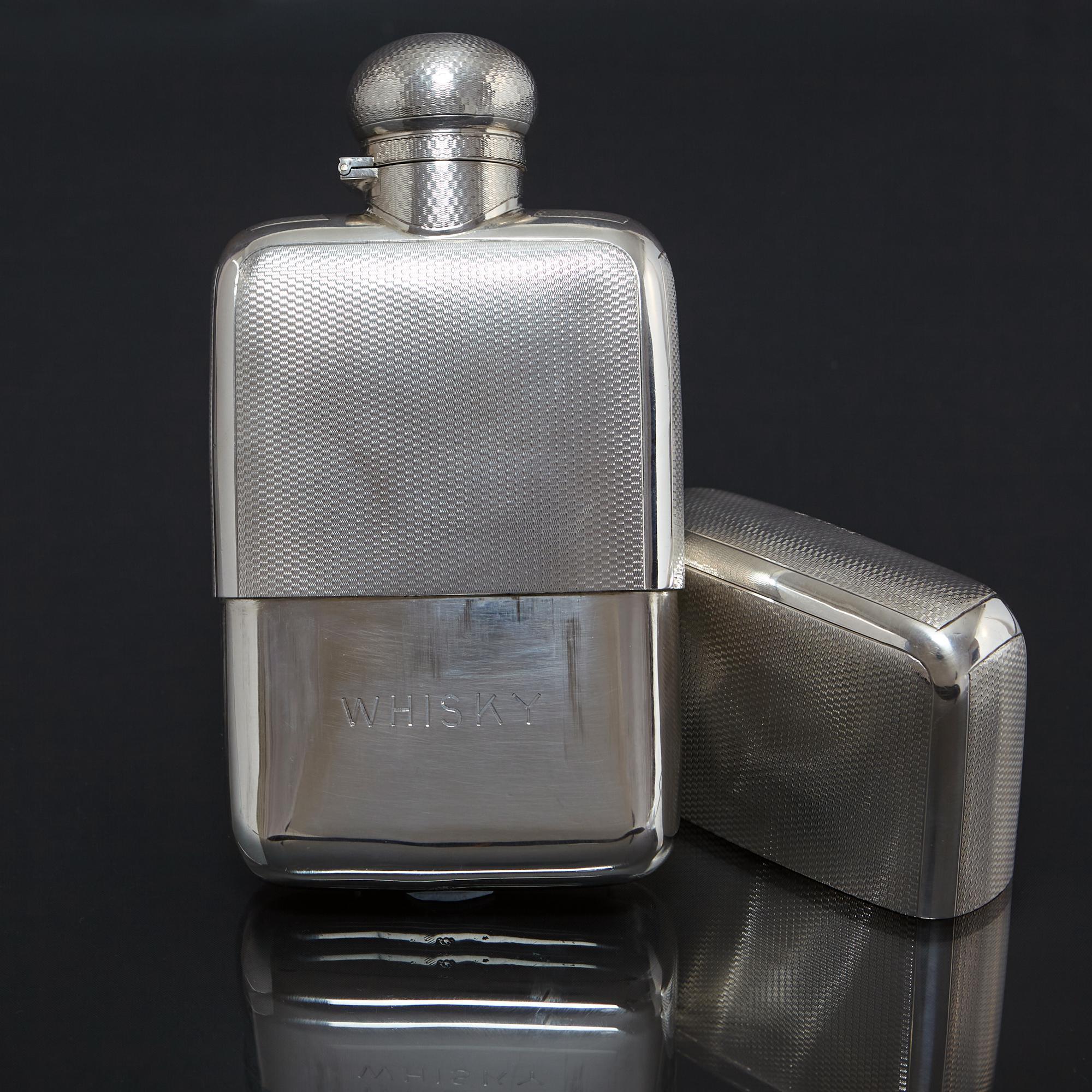 A large and exceptionally fine quality silver hipflask with slide-off cup and fitted with a one-twist, bayonet domed cover. All parts are beautifully decorated with classic engine-turned engraving with the plain body inside the cup engraved with the