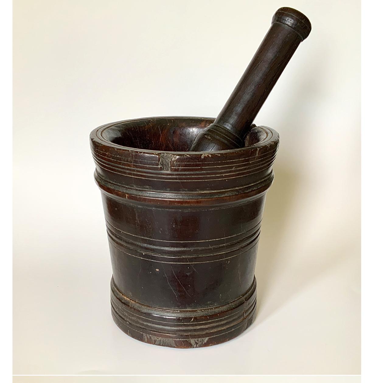 A Large 17th-18th Century Lignum Vitae English Mortar and Pestle. Lignum Vitae is one of the worlds heaviest, densest wood. This original Mortar & Pestle features a circular form with turned details and a beautiful finish with hundreds of years of