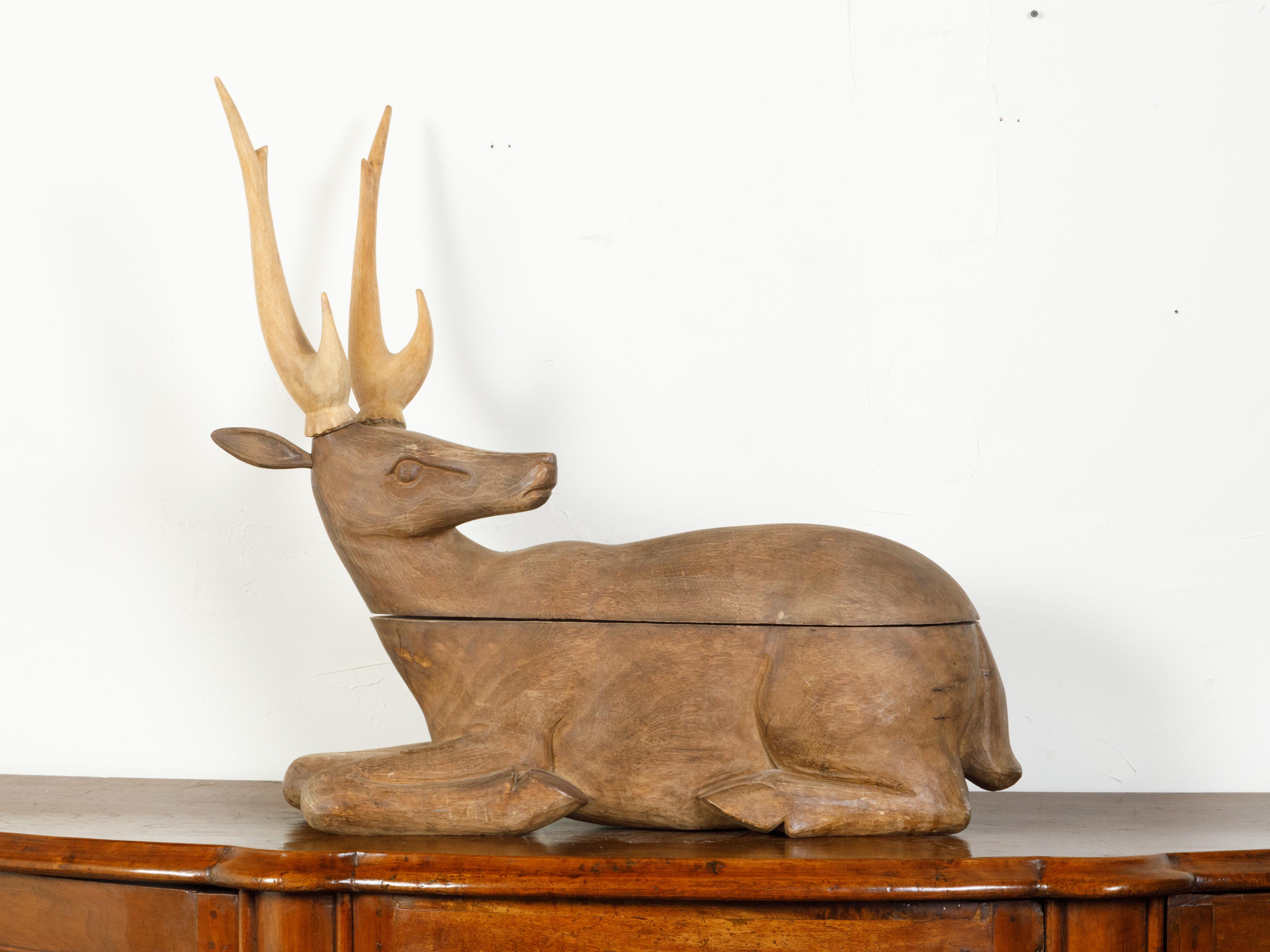 A large English carved wooden box from the early 20th century, depicting a stag. Created in England during the second quarter of the 20th century, this decorative box captures our attention with its simple yet elegant depiction of a reclining stag,