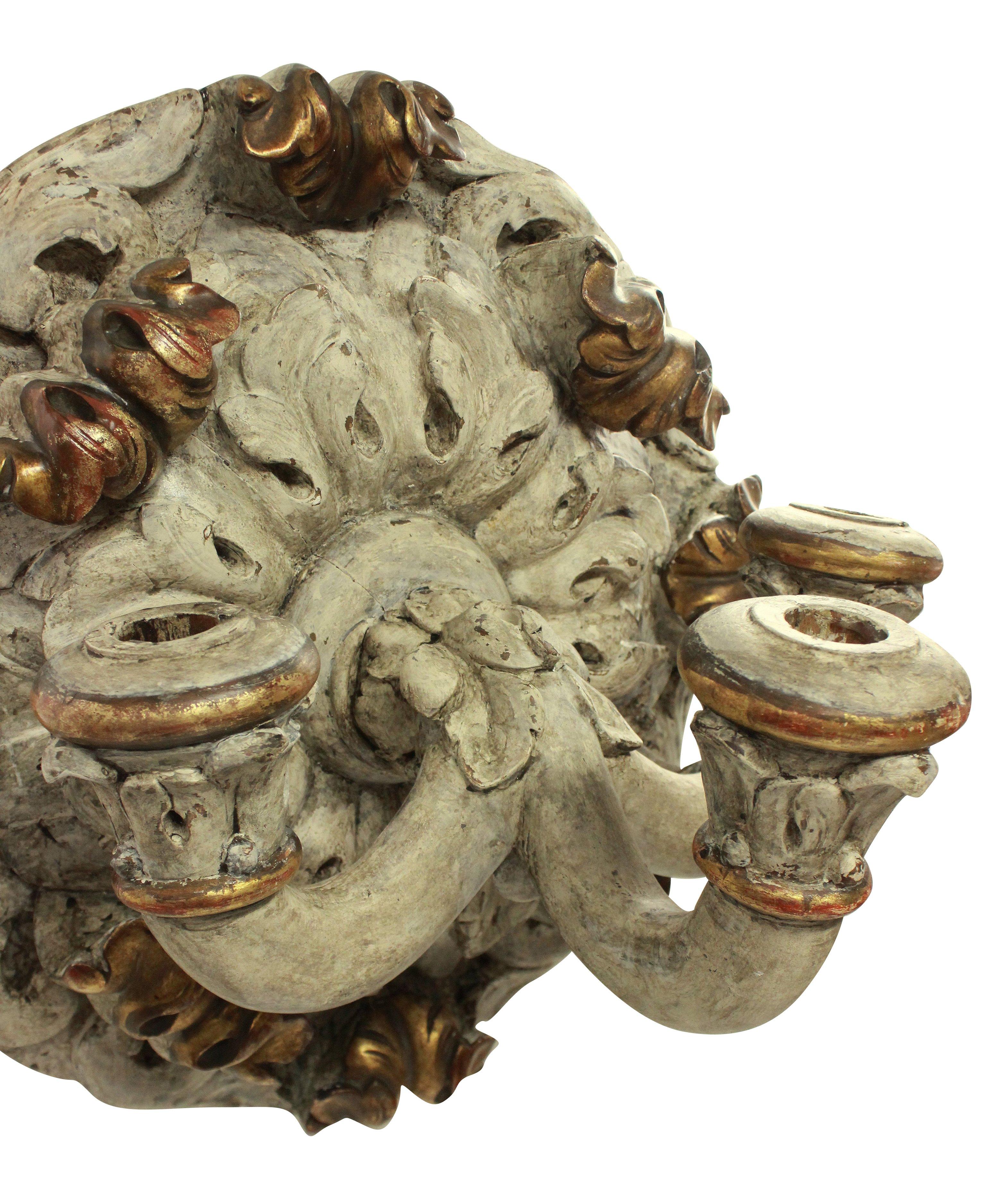 A large English 19th century carved three branch wall sconce in distressed paint and parcel gilt. Not electrified.