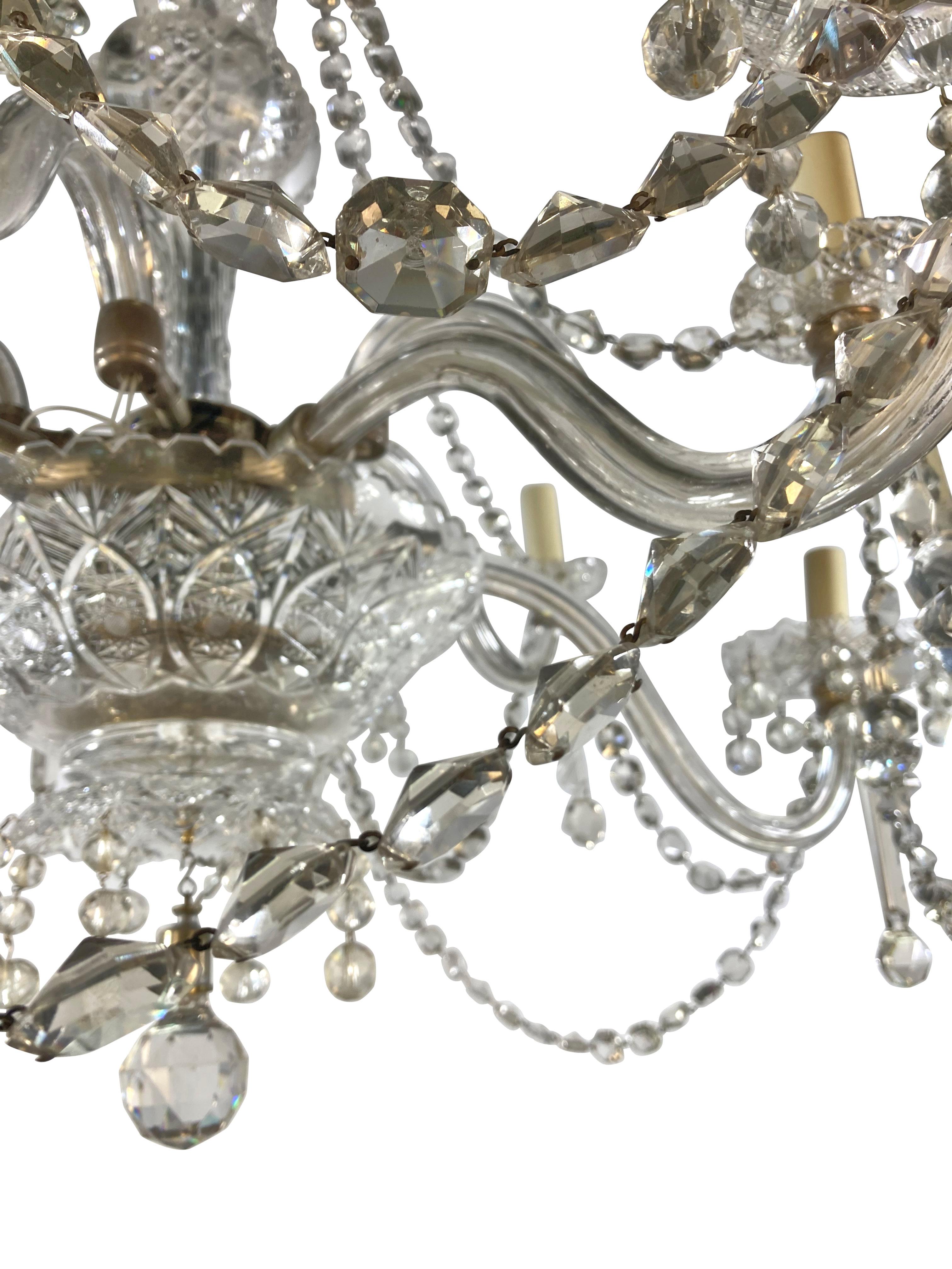 Un grand lustre victorien en verre taillé à dix lumières, de belle qualité. Anciennement un gazolier, avec des bras en verre creux disposés sur deux niveaux et suspendus à travers des prismes, des 