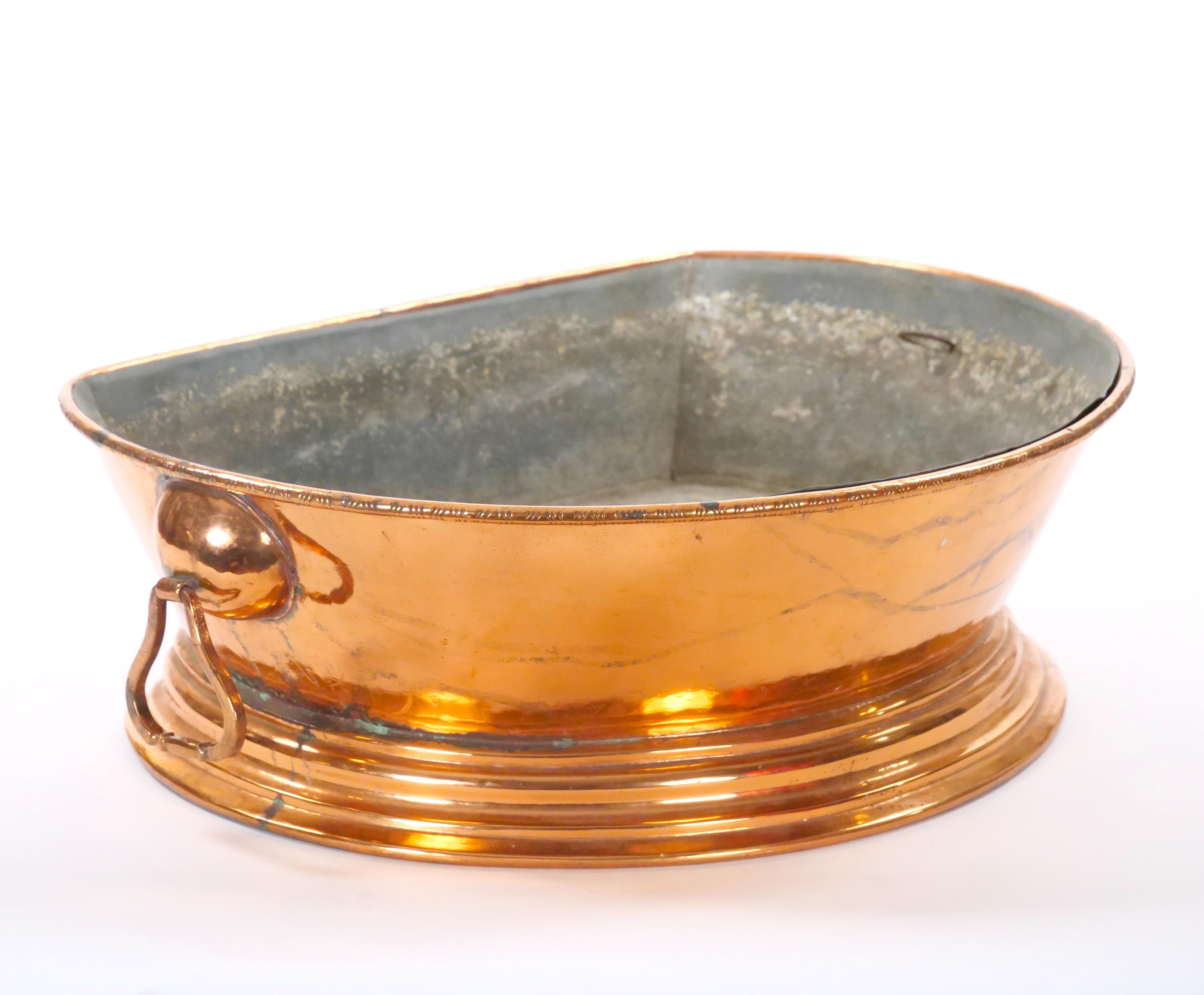 Questo sostanzioso lavabo inglese in rame della metà del XIX secolo emana un'eleganza classica e una superba maestria. Il lavabo presenta un corpo ovale splendidamente curvo montato su una base ovale coordinata, che conferisce un senso di simmetria