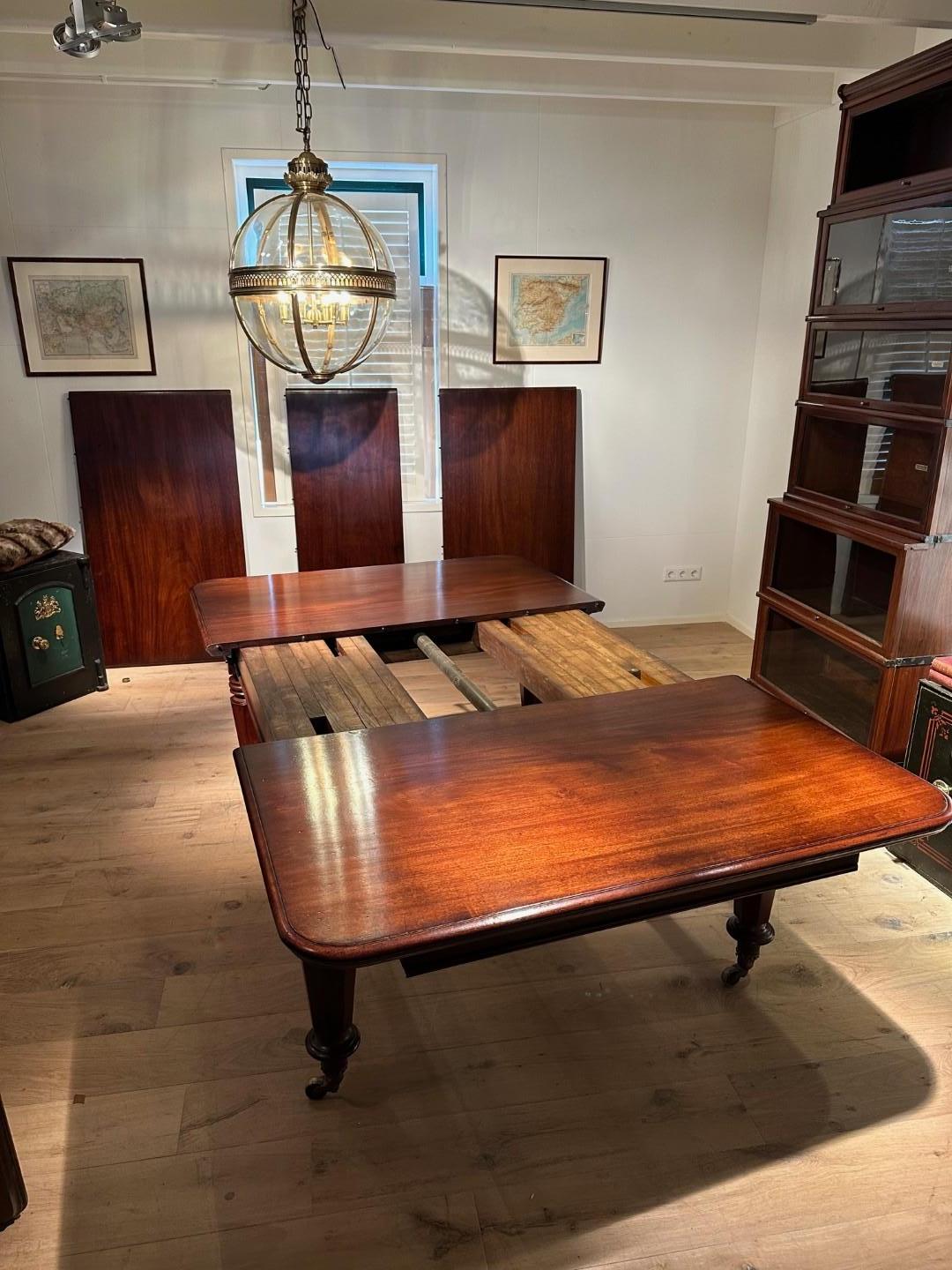 Impressionnante table de salle à manger ancienne en acajou anglais en très bon état d'origine. La table peut être composée à l'aide de trois feuilles supplémentaires originales de différentes tailles. La table pivote vers l'extérieur à l'aide d'un