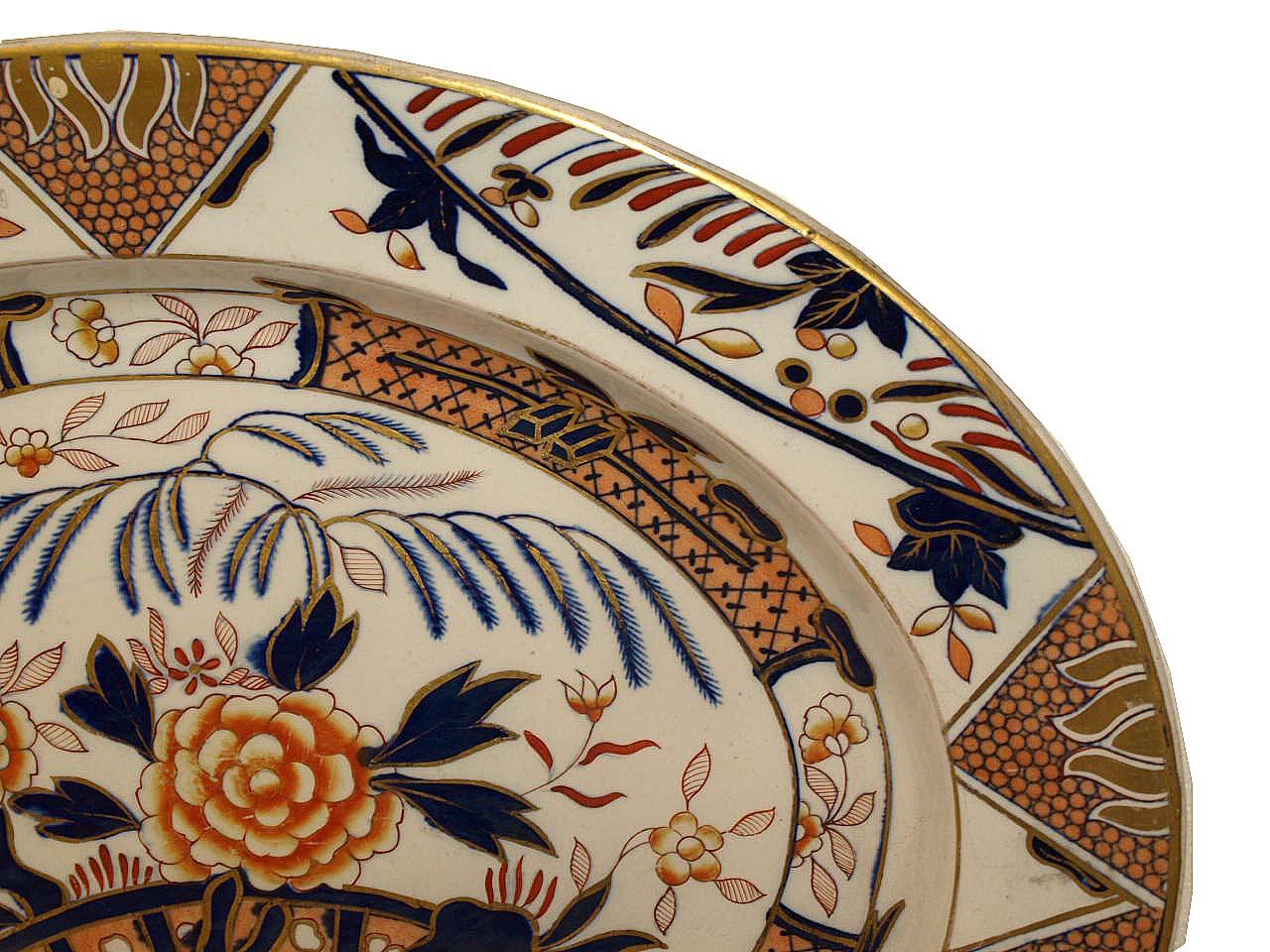 English Ashworth ironstone platter, featuring various shades of coral and navy blue on a white background displaying a multitude of flowers and foliate throughout, all highlighted with gilt. It has an impressed mark 