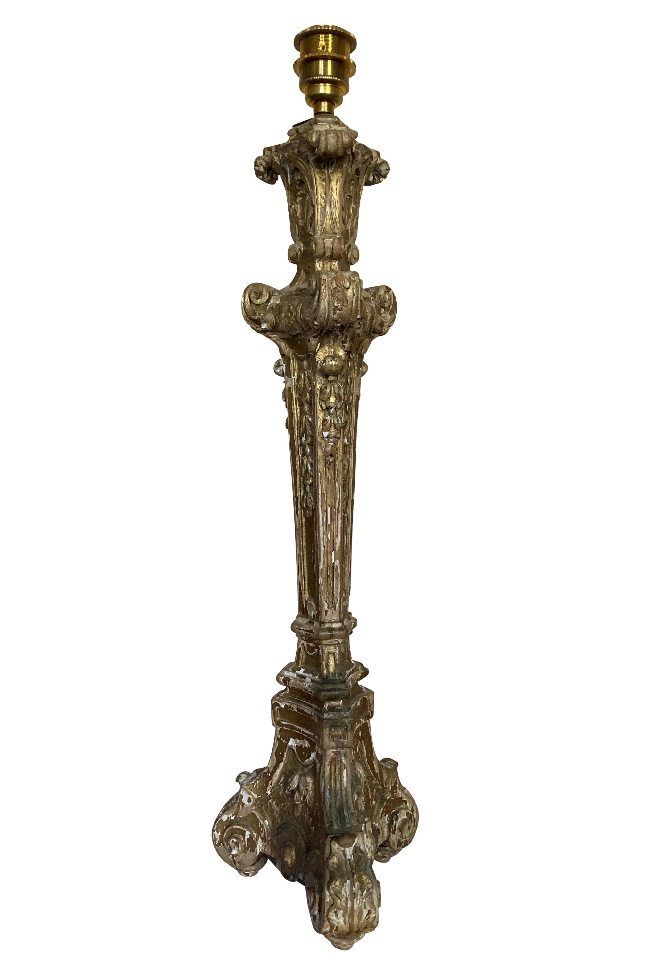 A large English Baroque carved lamp with traces of the original gilding, in a dry, country House condition. Wired with an antique gold silk cord with switch.