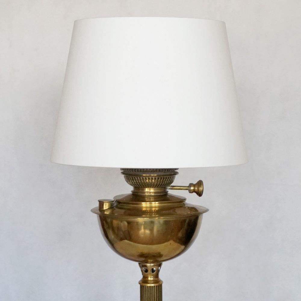 Antique English brass oil lamp, converted to electrical table lamp. Fluted column on four feet brass base. Recently rewired with one brass Edison E-27 light socket for a large sized bulb. New off-white cotton shade included.
Measures:
Height 25