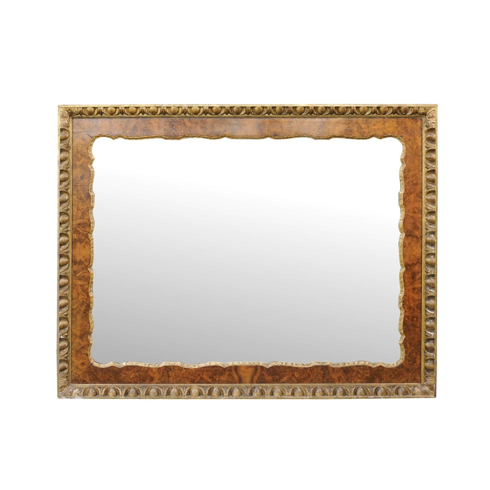 A large English burl wood mirror from the late 19th century, with gilt accents and egg and dart motifs. Born in England during the third quarter of the 19th century, this large mirror will look wonderful displayed vertically or horizontally.