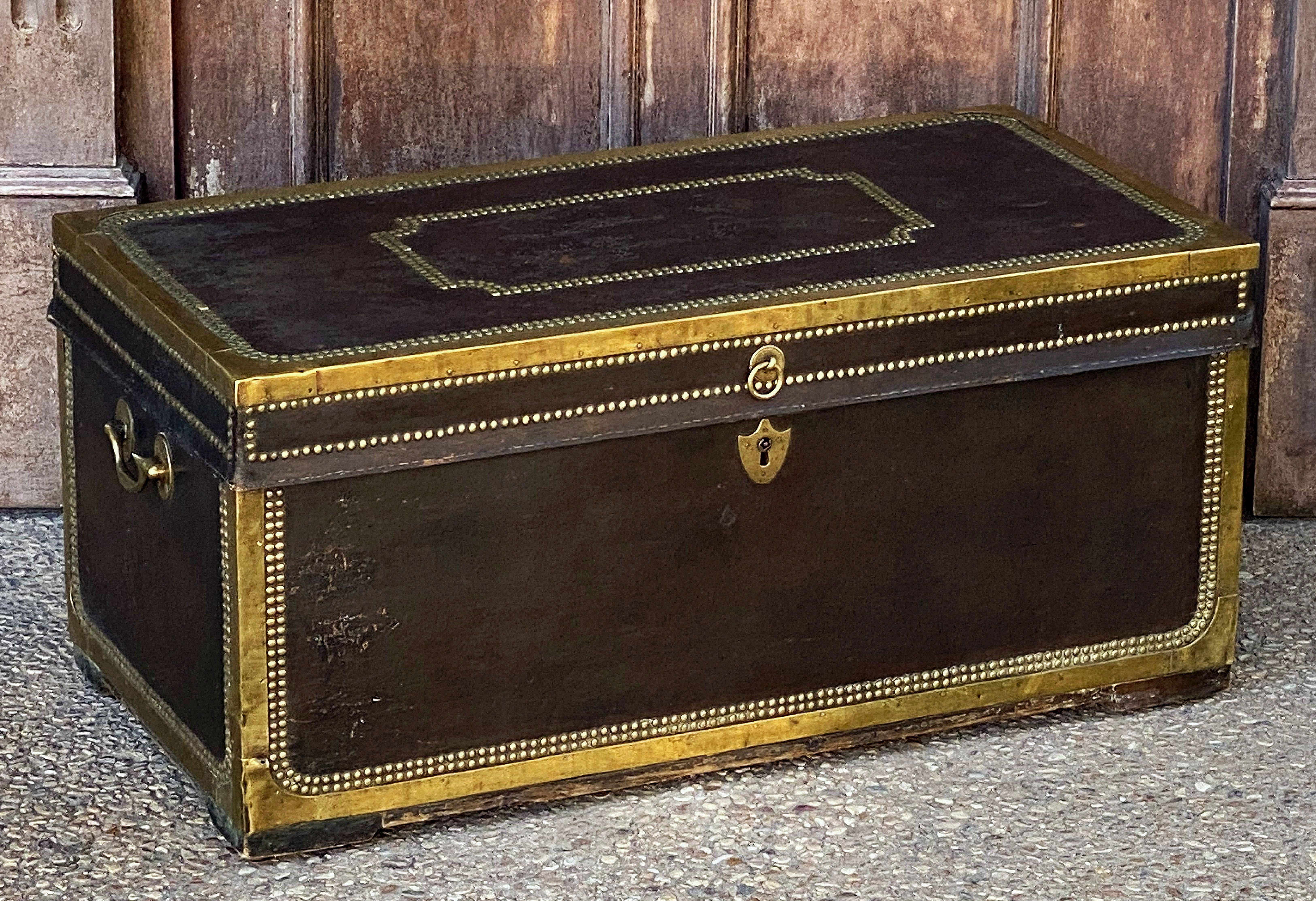 A handsome large-sized British officer's military or naval Campaign camphor trunk or chest of brass-bound and studded leather over camphor wood, circa 1820.
Manufactured by the British East India Company for an officer to carry his kit on