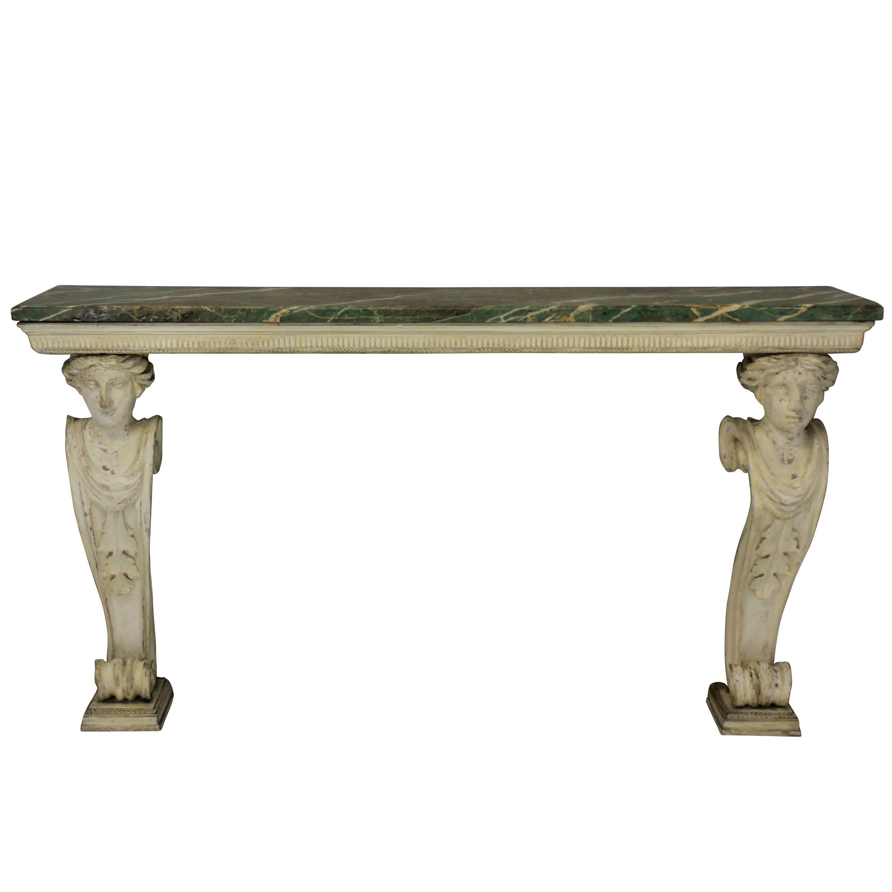 A large English console table in the manner of William Kent, finely carved with the original gesso showing. It comprises two caryatids with scrolled backs, supporting a simple frieze with an unusual marble top in pale greens.

