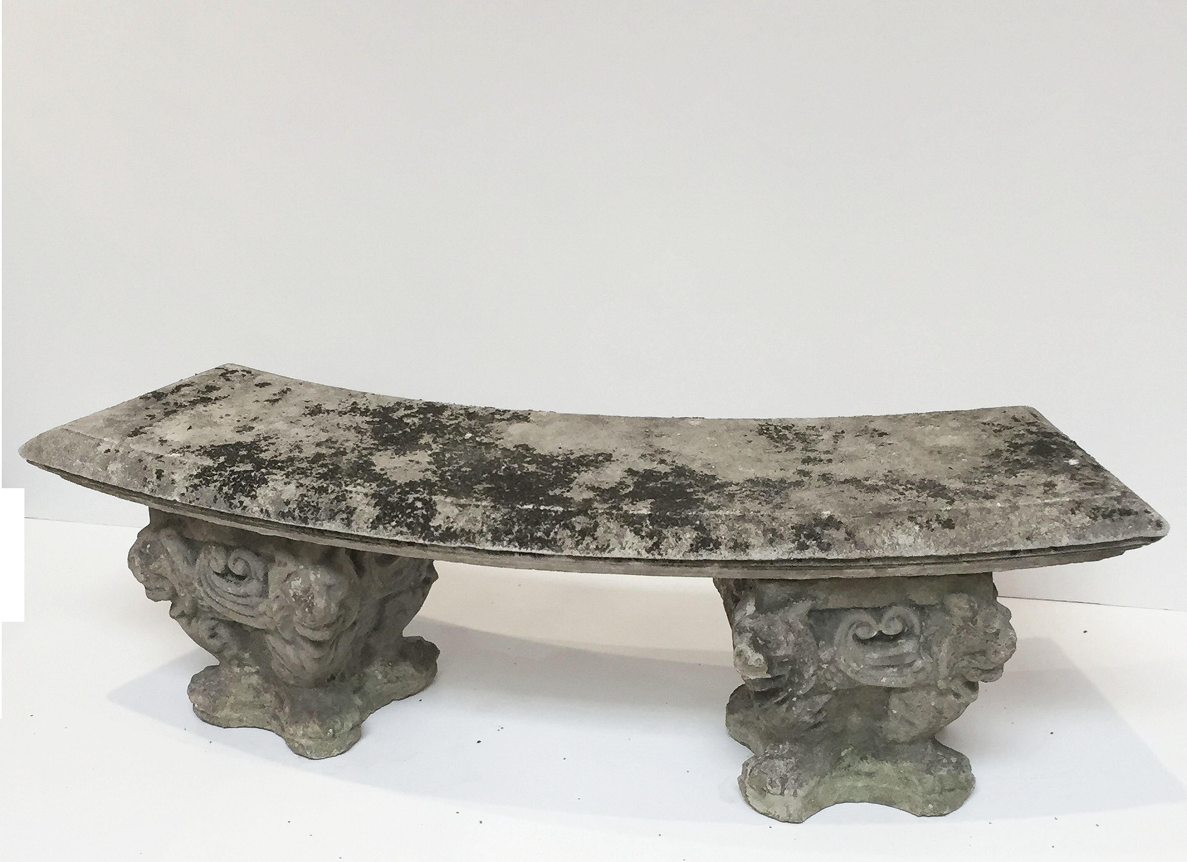 A fine English large garden bench or seat of composition stone, featuring a curved top (59 inches length), set upon two plinth supports with a lion and scroll design.

Great for an indoor or outdoor garden, garden room, or conservatory!