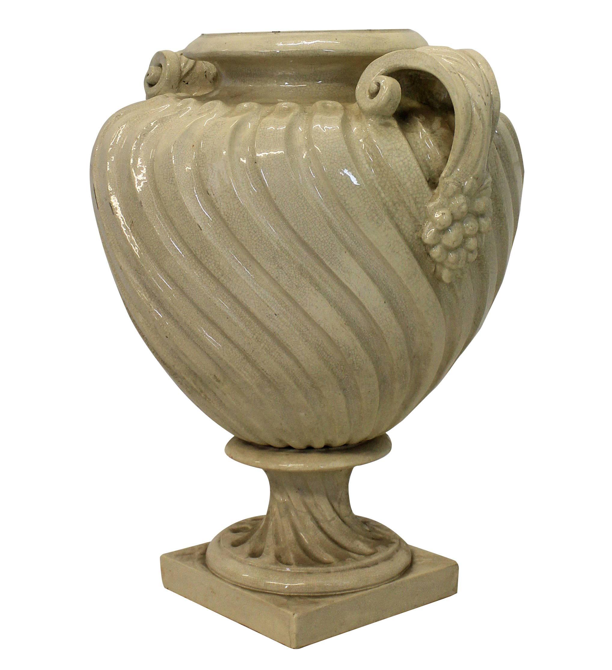 A large English Doulton twin handled urn of unusual shape and design in a cream glaze.