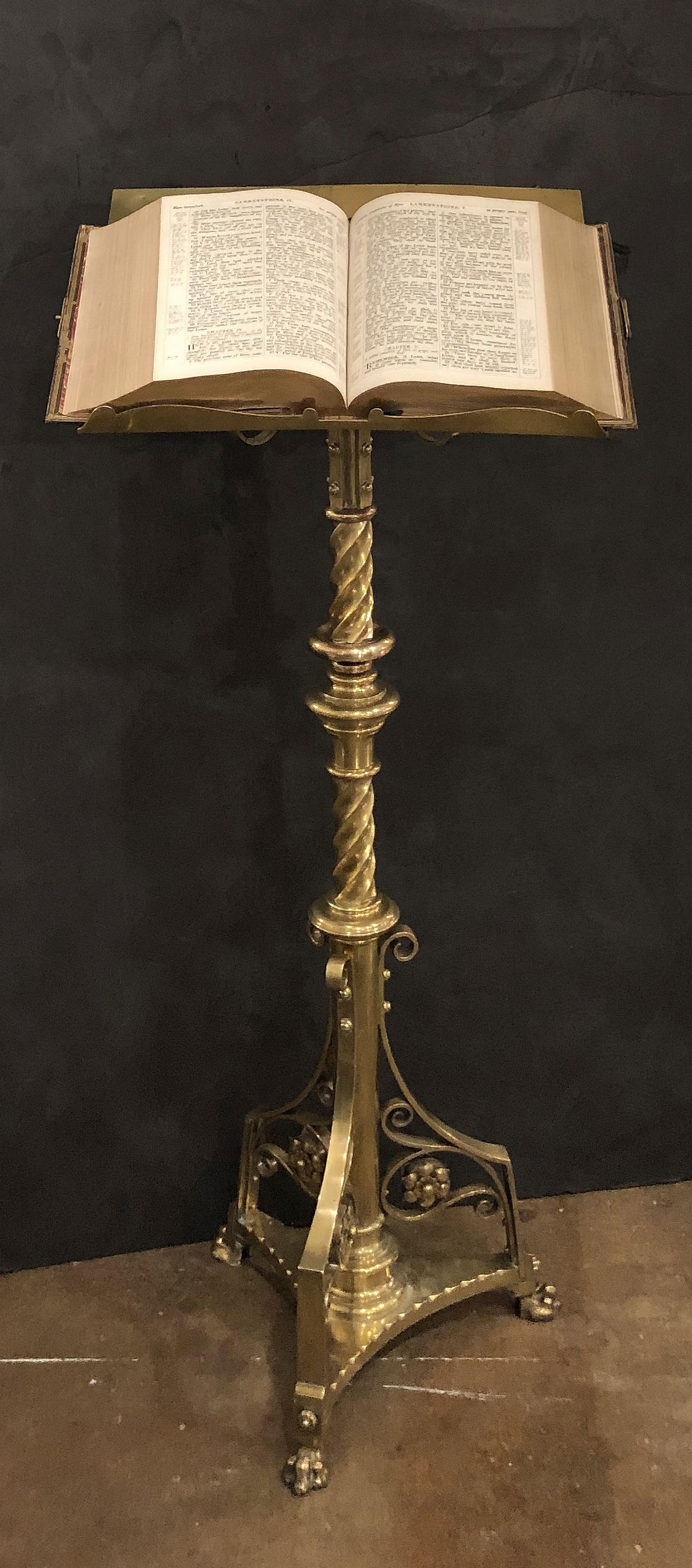 A handsome large English ecclesiastical standing lectern of brass, featuring a rotating easel top with a design of quatrefoils surrounding a center quatrefoil with fleur-de-lis, one side with slanted support rest for a book, mounted to a decorative
