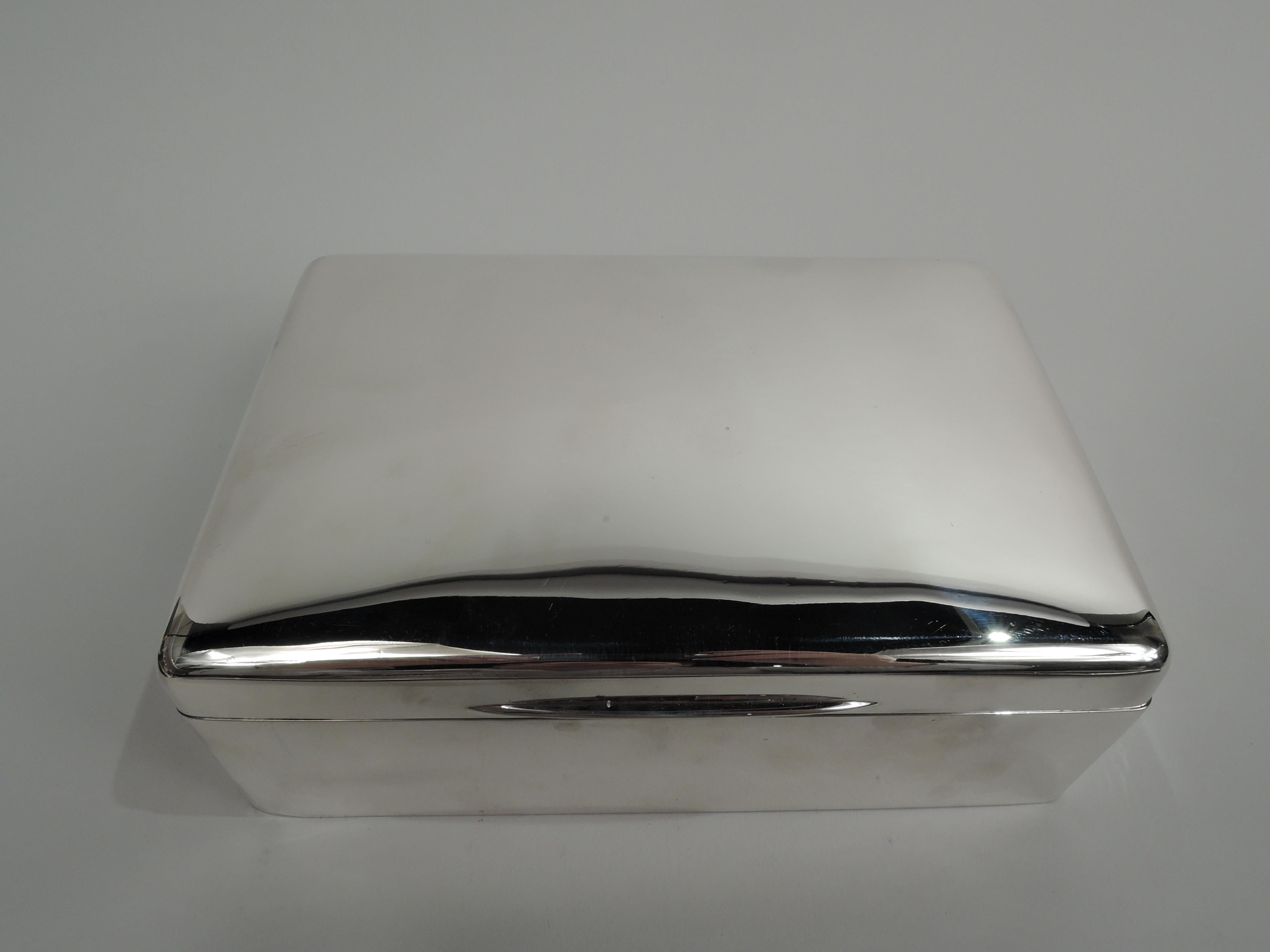 Large English Edwardian Modern sterling silver box, 1903. Rectangular with straight sides and curved corners. Cover flat and hinged with tapering tab. Box interior cedar-lined and -partitioned. Cover interior gilt-washed. Box underside