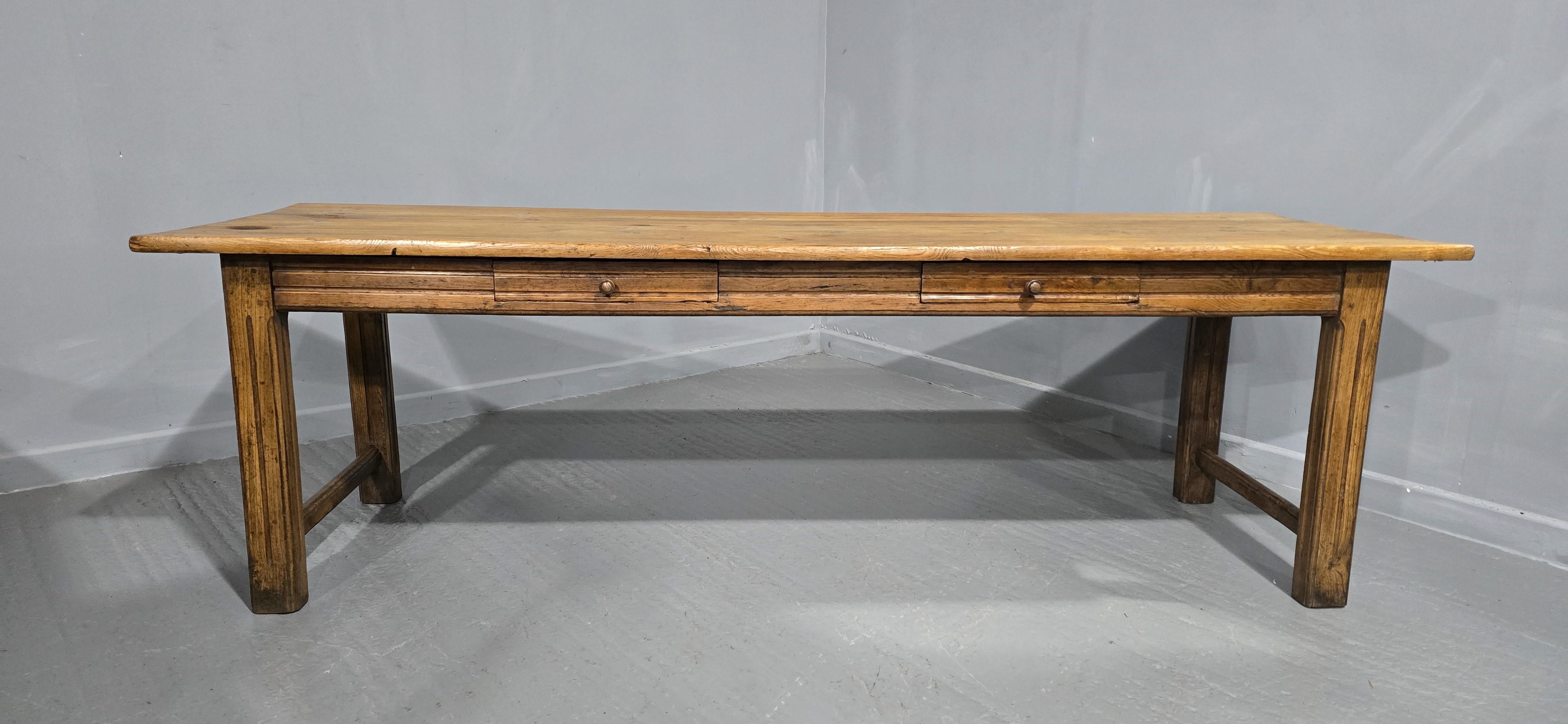 A super English three plank pine farmhouse table with elm base, two opening drawers to one side, waxed finish, honey coloured.

97