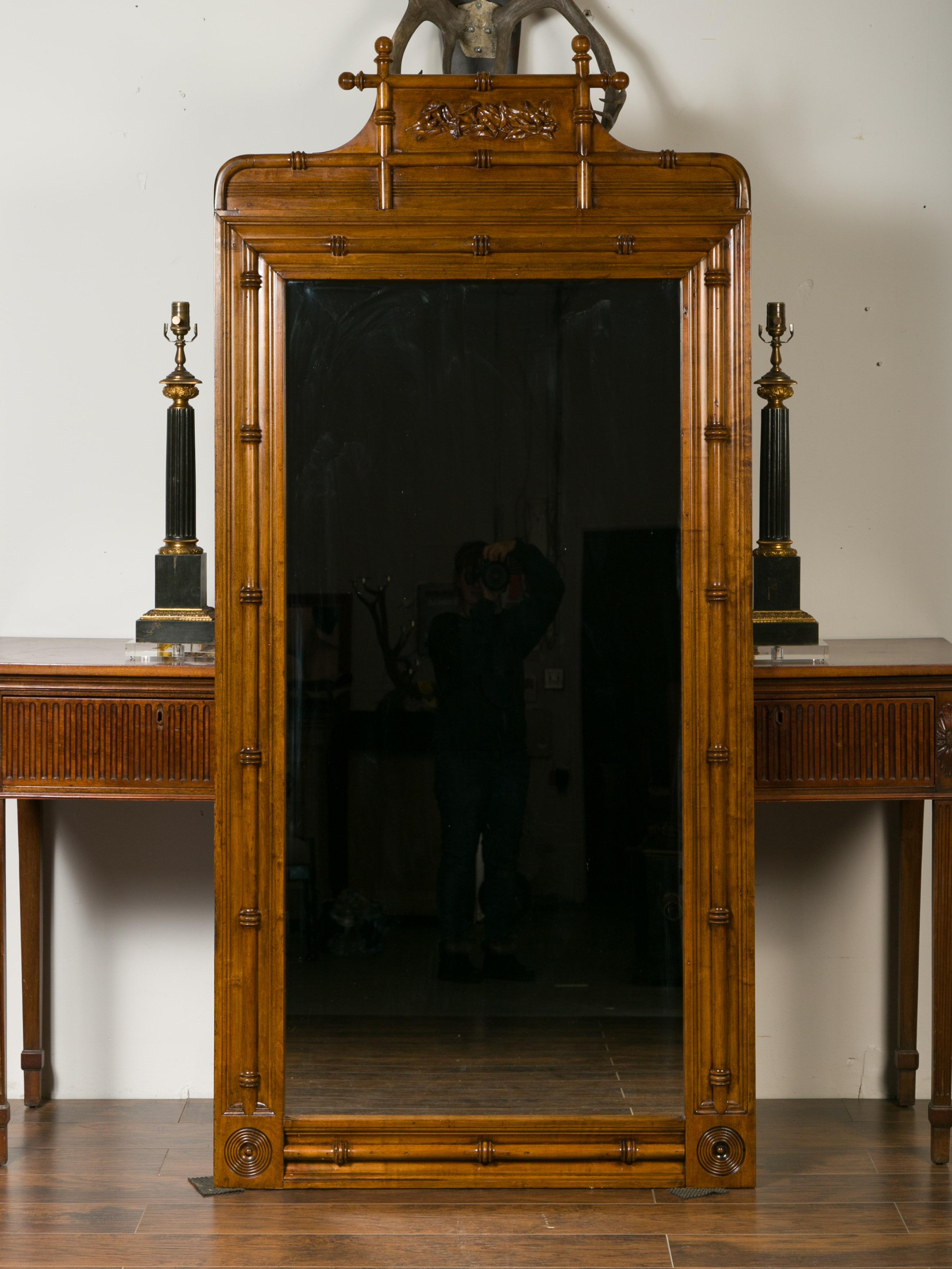 Un grand miroir anglais en noyer faux-bambou fabriqué à partir de vieilles portes du début du 20e siècle, avec des motifs de lierre sculptés. Attirant notre regard par sa haute silhouette et sa patine brune, ce miroir en noyer est fabriqué à partir